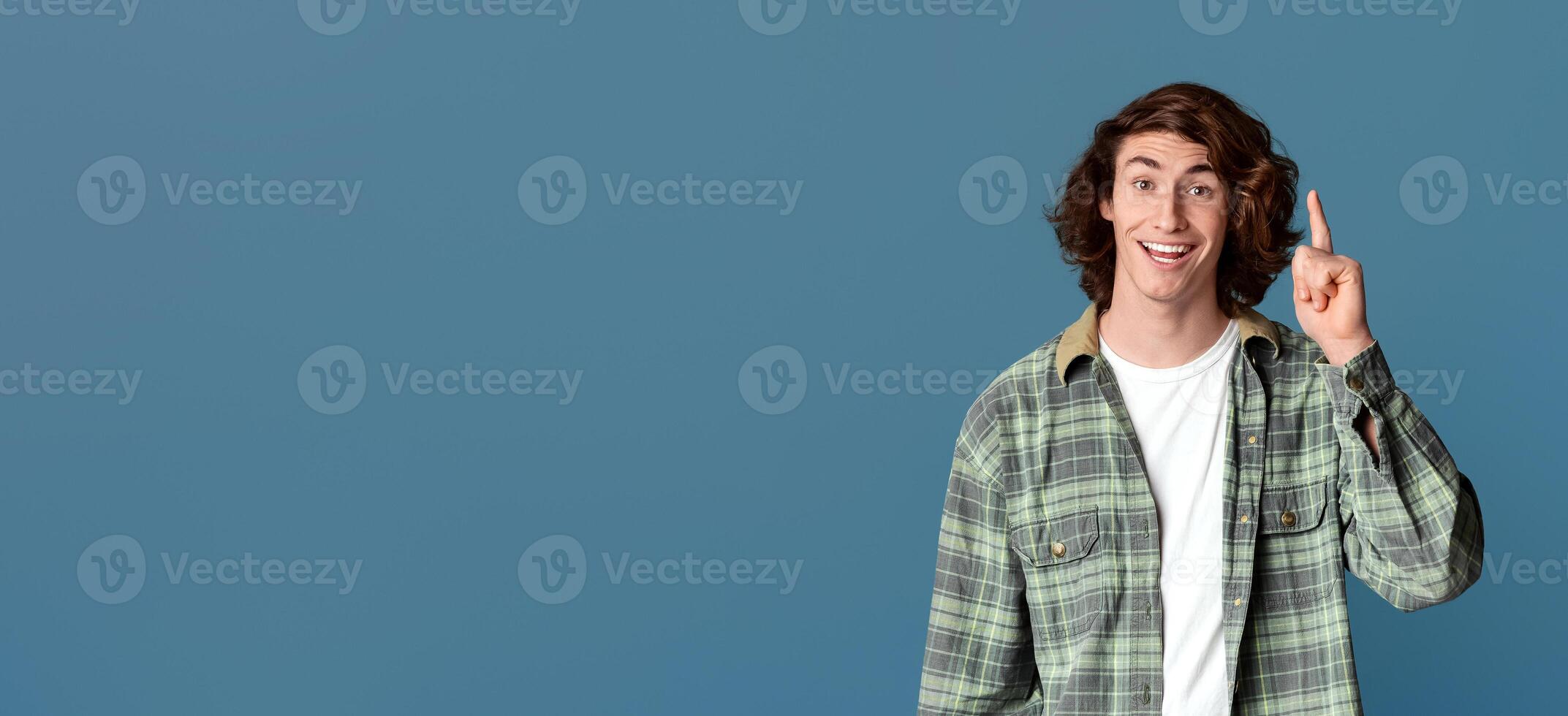 Happy young guy having brilliant idea, gesturing EUREKA on turquoise background photo