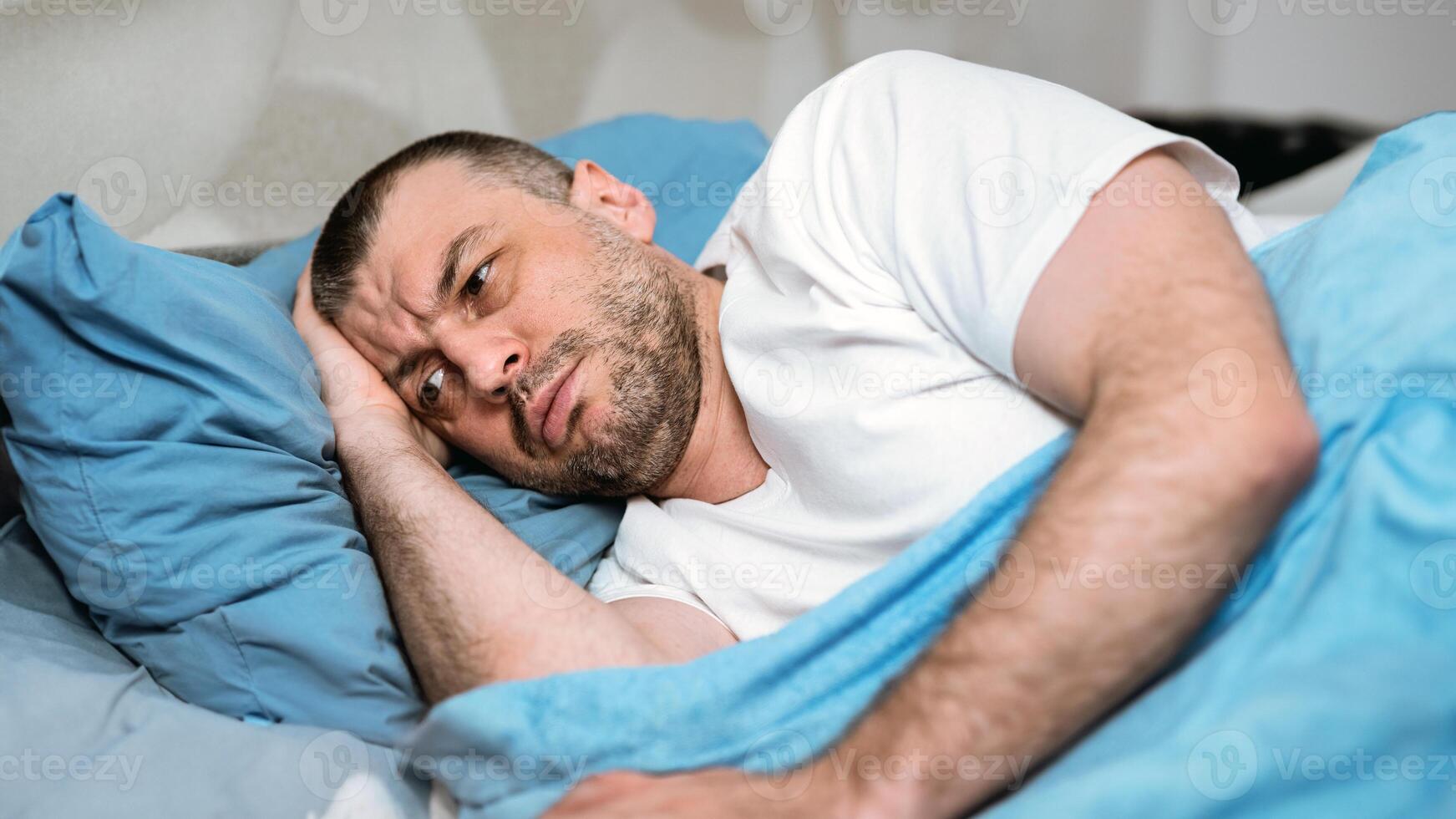 Anxiety And Sleeplessness. Middle-Aged Man Having Insomnia Lying In Bed At Home During Coronavirus Self-Isolation photo