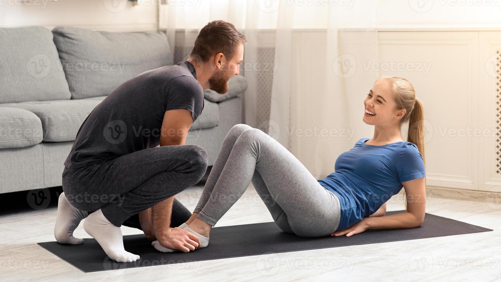 Personal fitness coach. Happy couple in love training together at home, free space photo