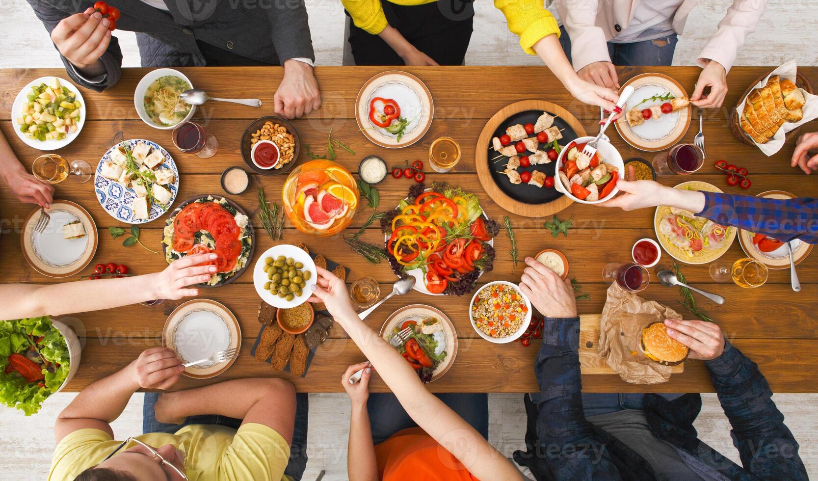 Friends dinner party, table top view. People eat healthy food together photo