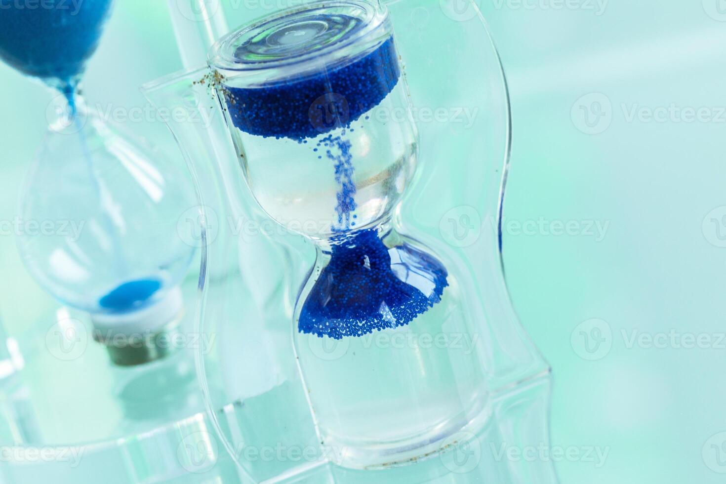 Time passing. Blue hourglass. photo