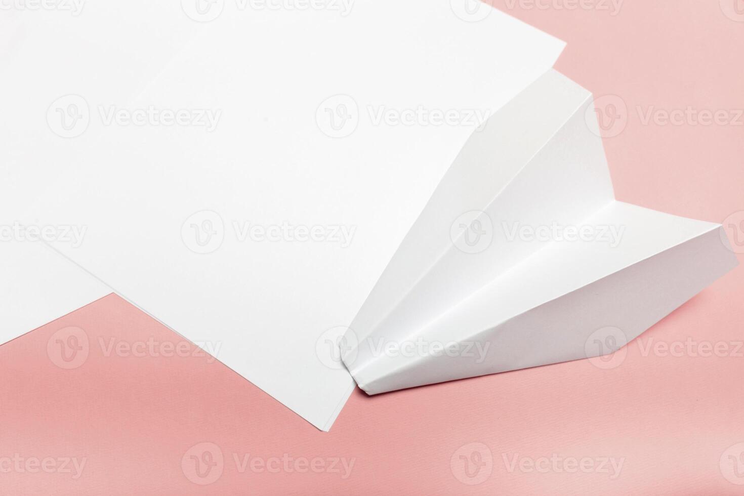 Blank paper on top of pink pastel desk photo