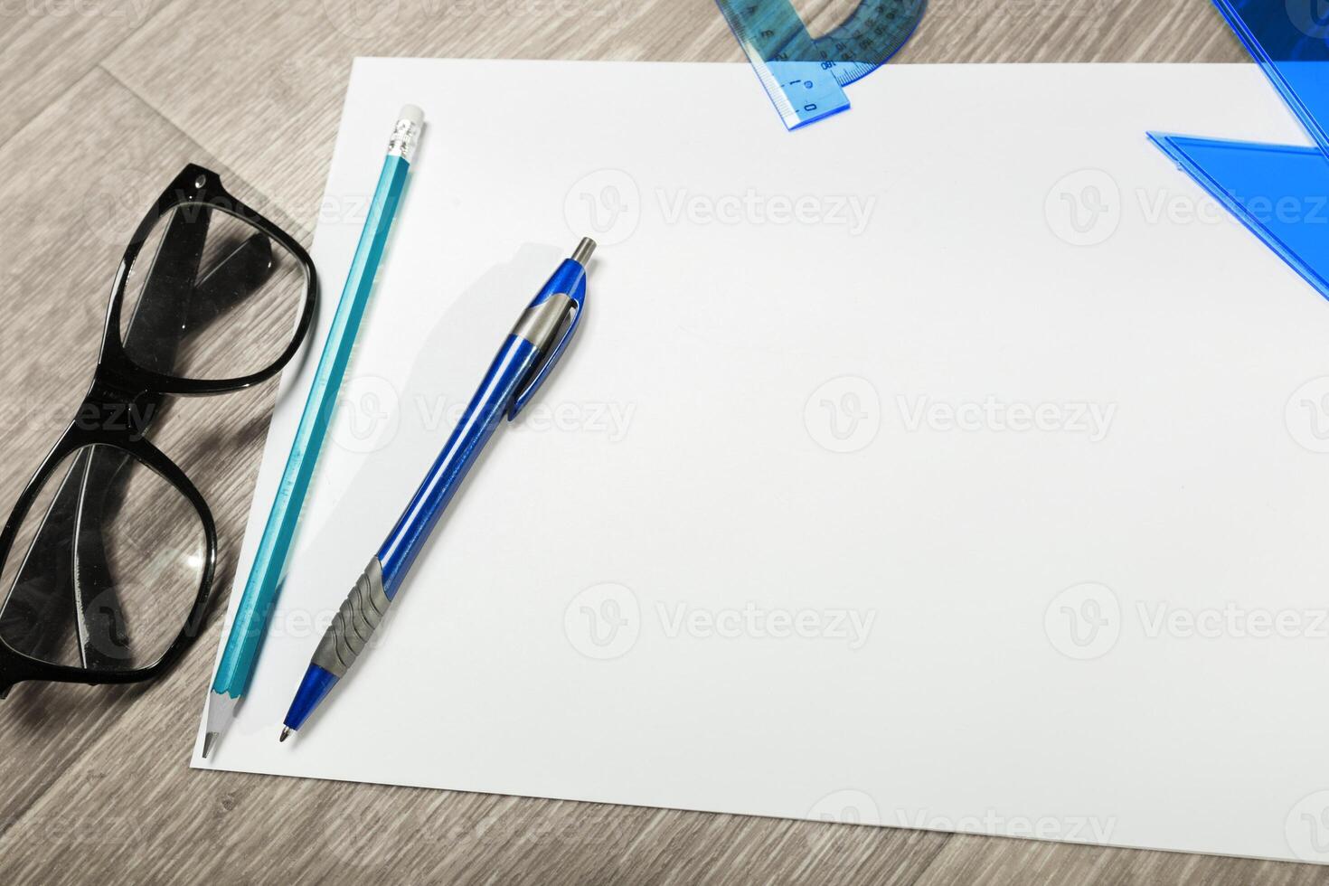 Blank notebook and pencil with glasses on wooden table photo