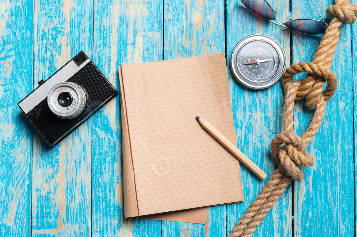 Retro camera and sheets of paper on table. photo