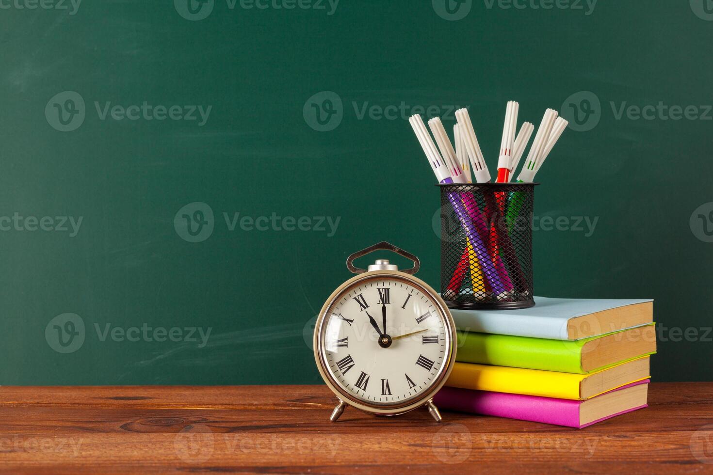 School supplies on a wooden table and blackboard photo