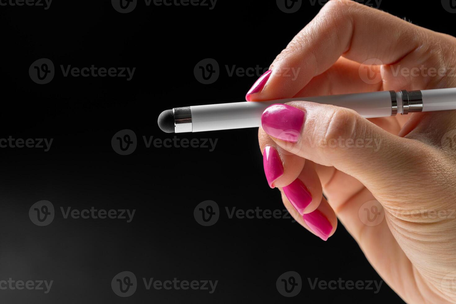 Female hand holding a pen close up photo