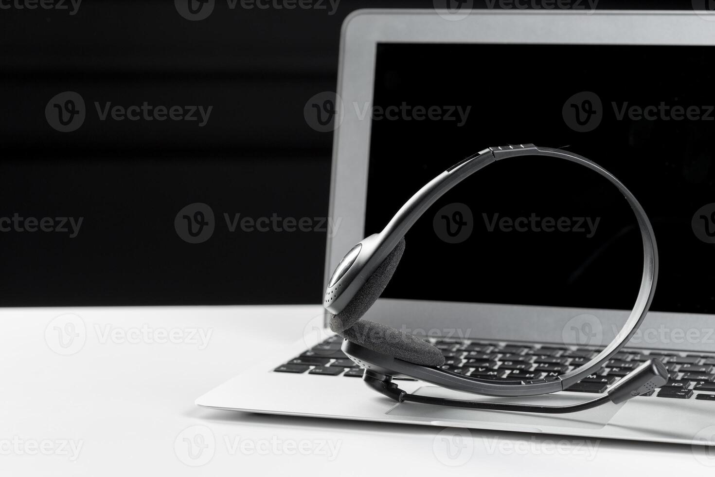 call center support concept. headset on keyboard computer laptop photo