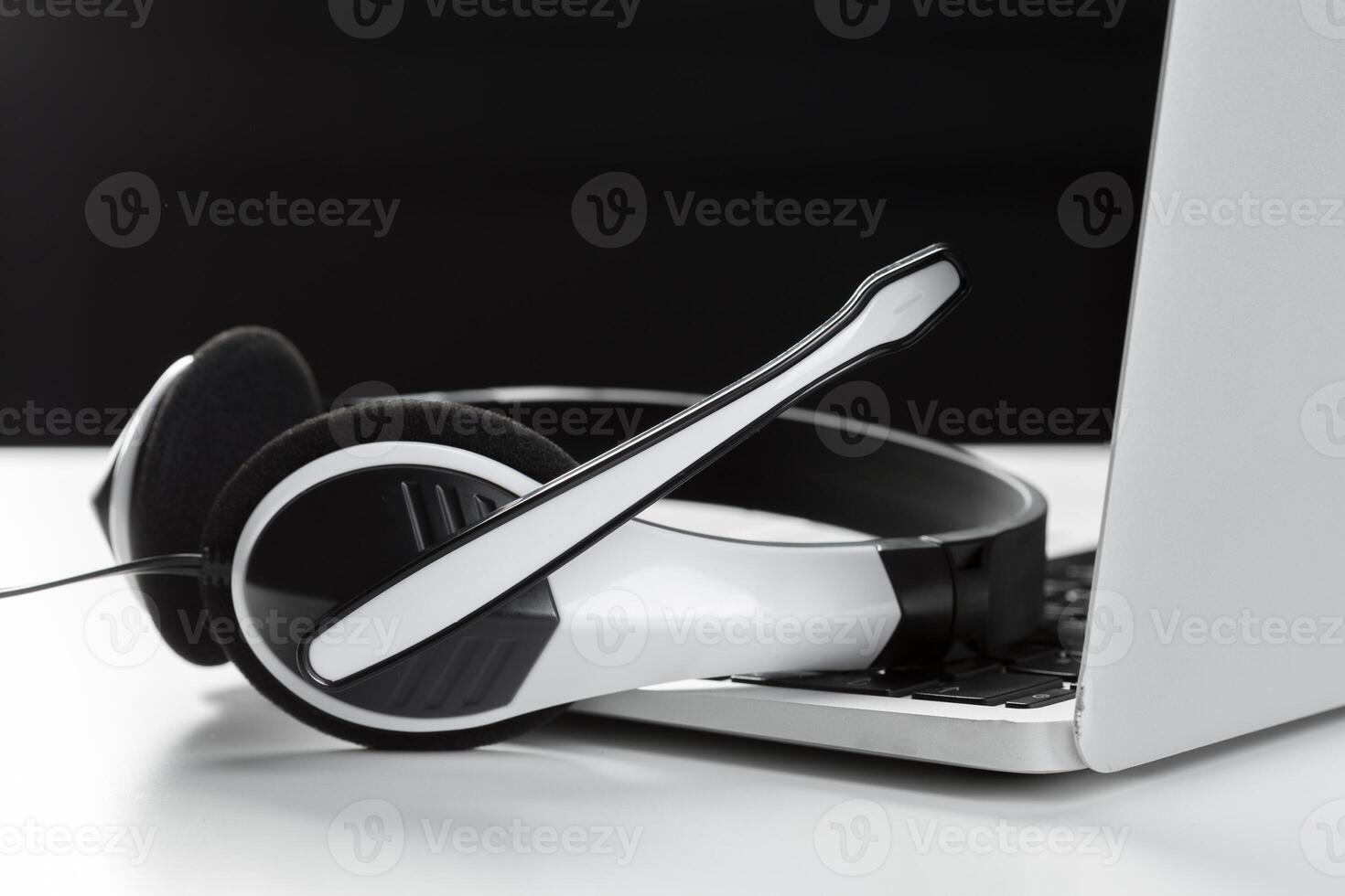 call center support concept. headset on keyboard computer laptop photo