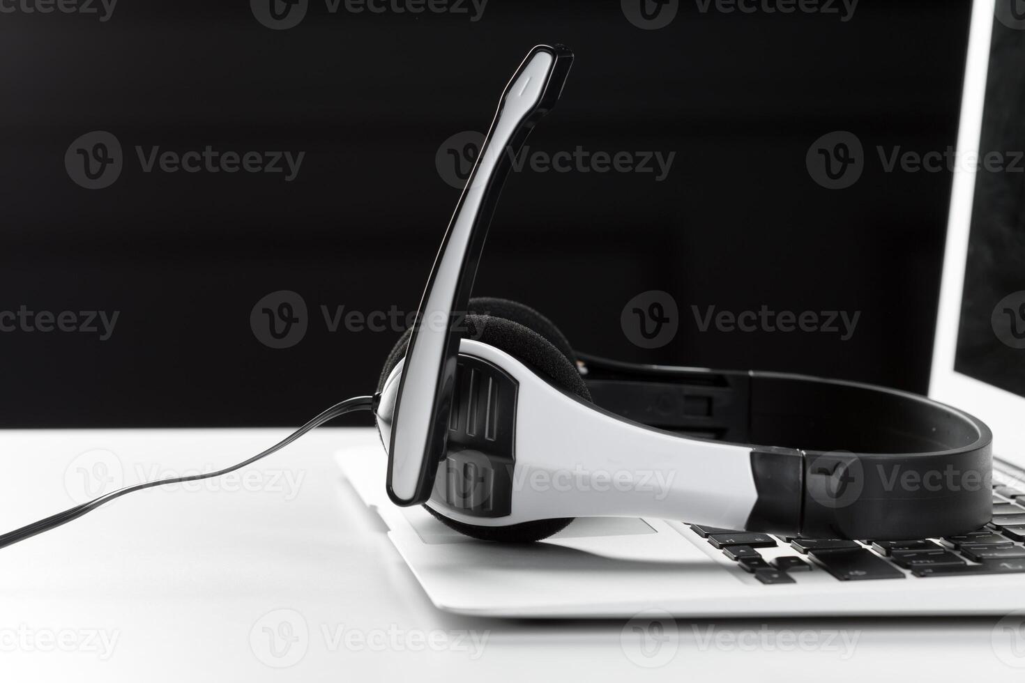 call center support concept. headset on keyboard computer laptop photo