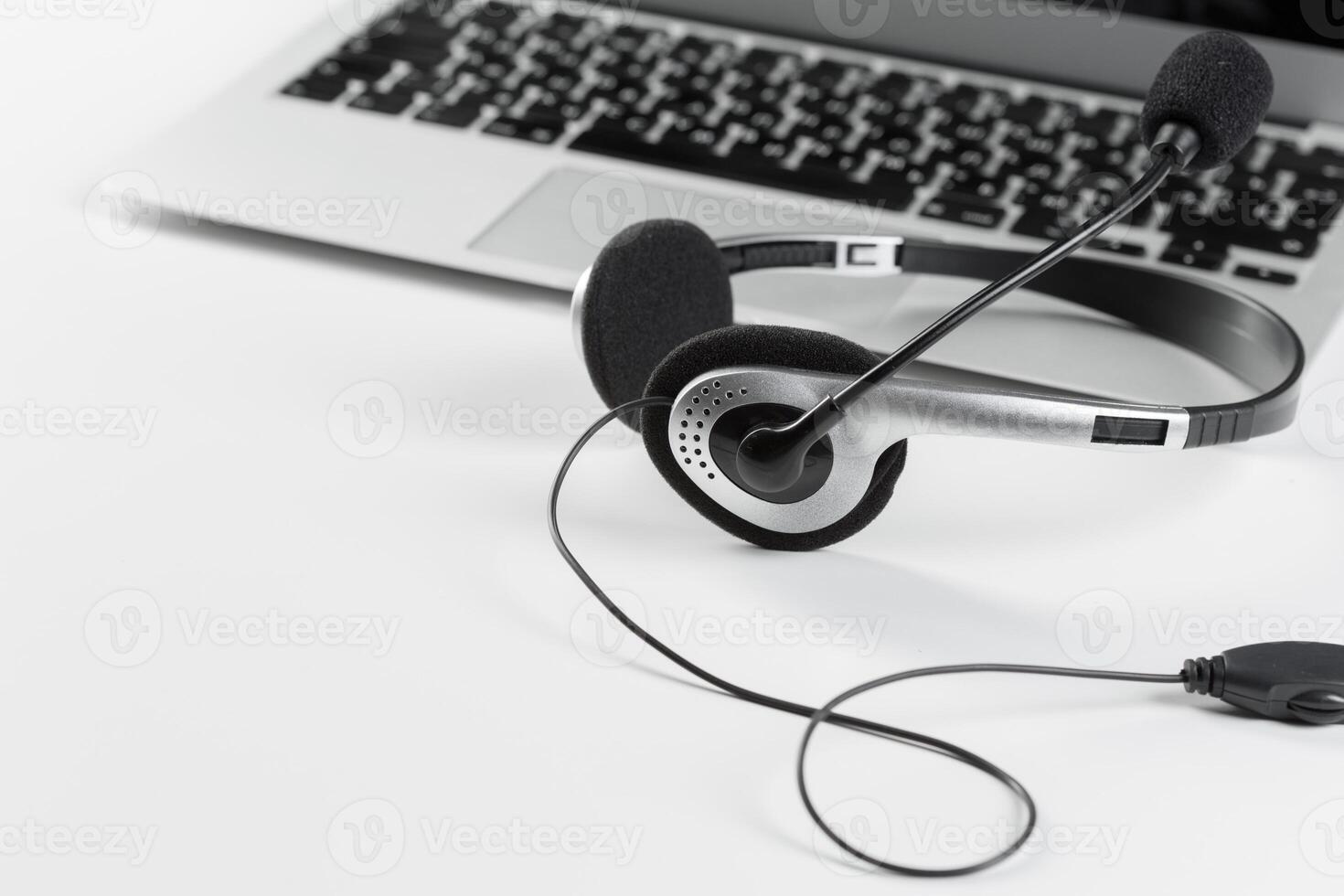 call center support concept. headset on keyboard computer laptop photo