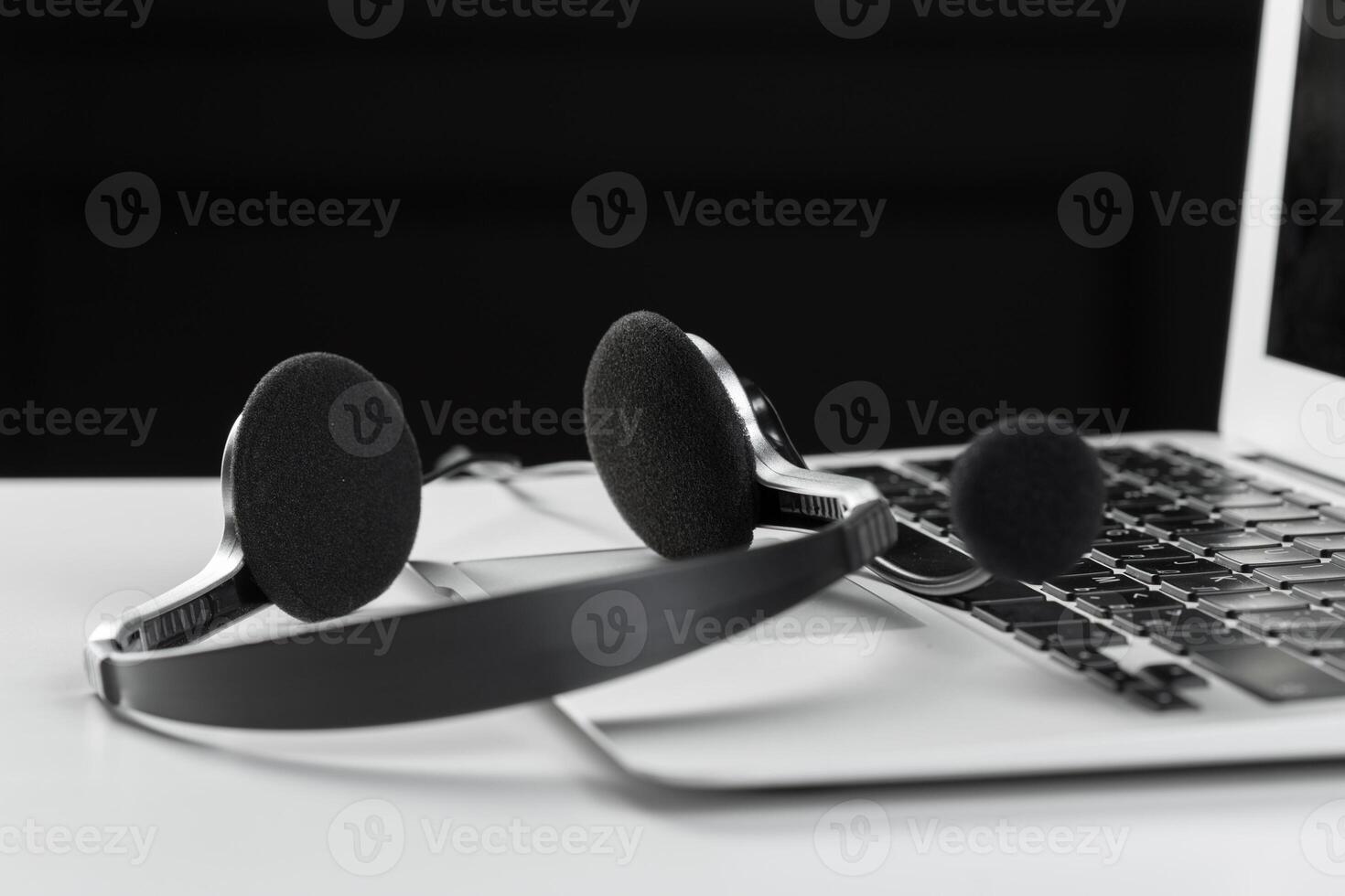 call center support concept. headset on keyboard computer laptop photo