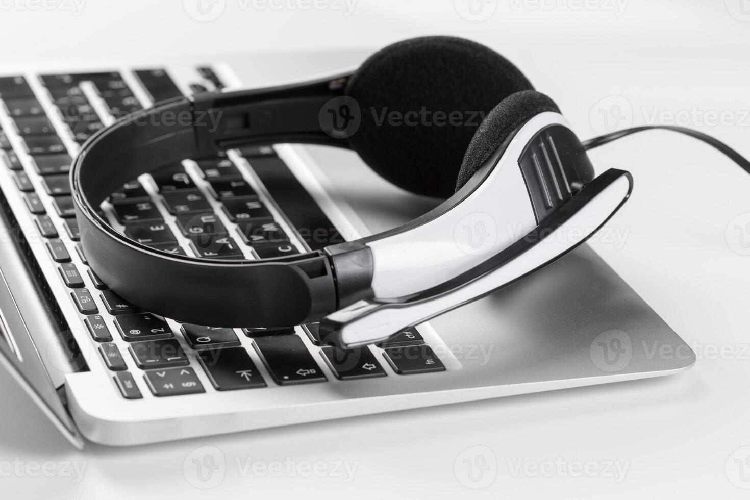 call center support concept. headset on keyboard computer laptop photo
