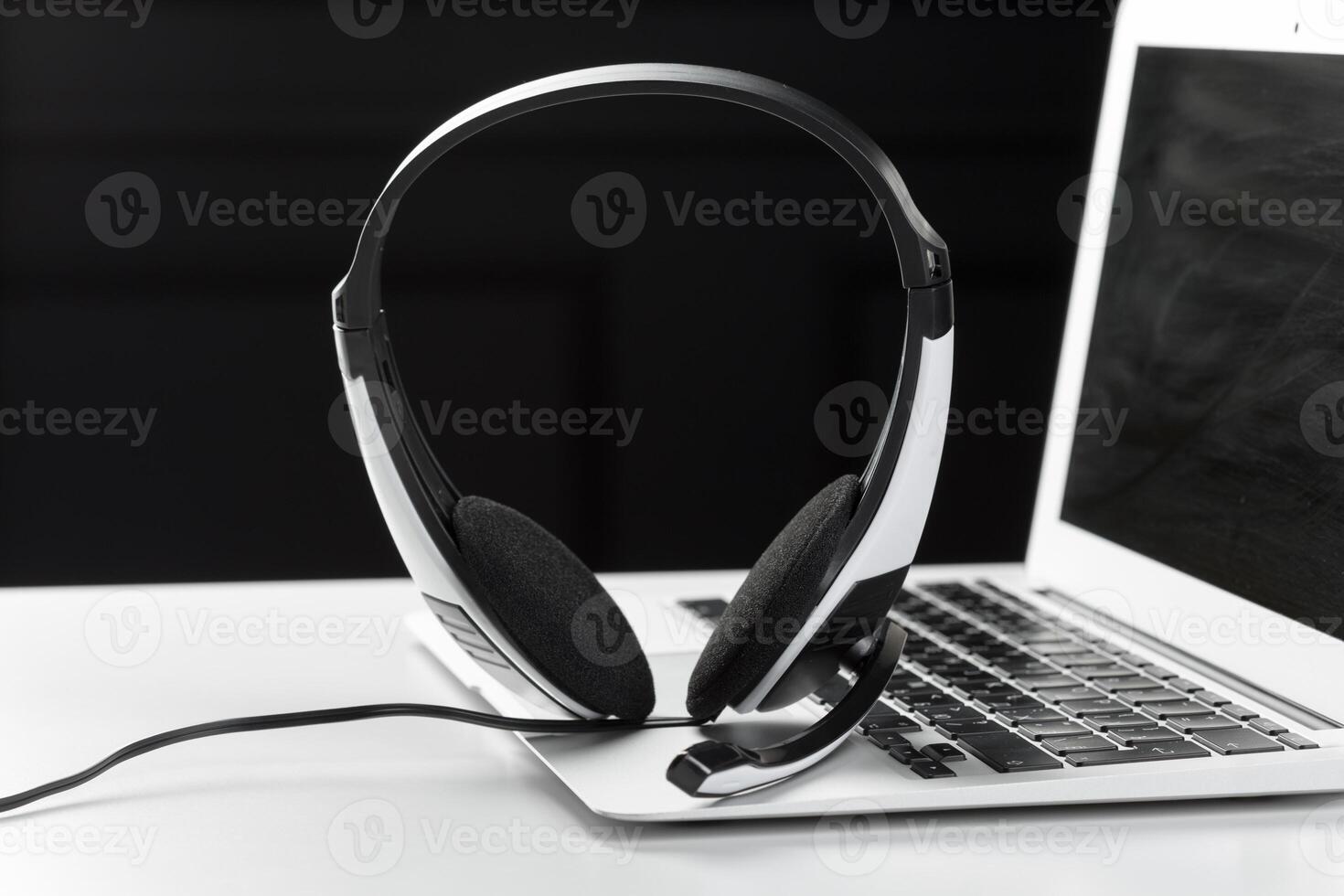 call center support concept. headset on keyboard computer laptop photo