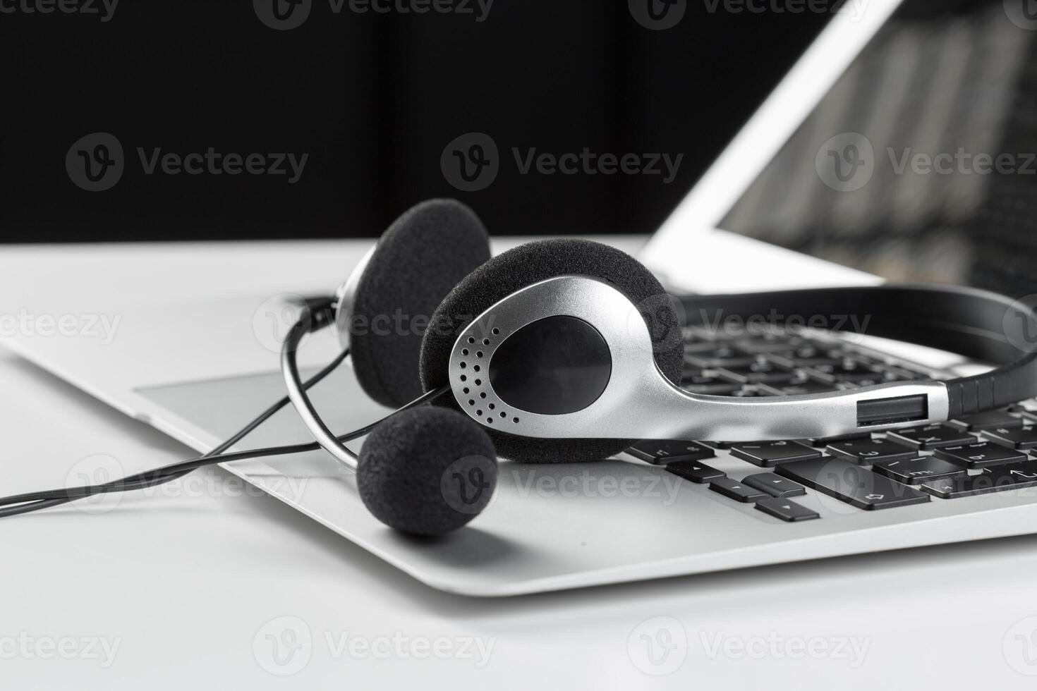 call center support concept. headset on keyboard computer laptop photo