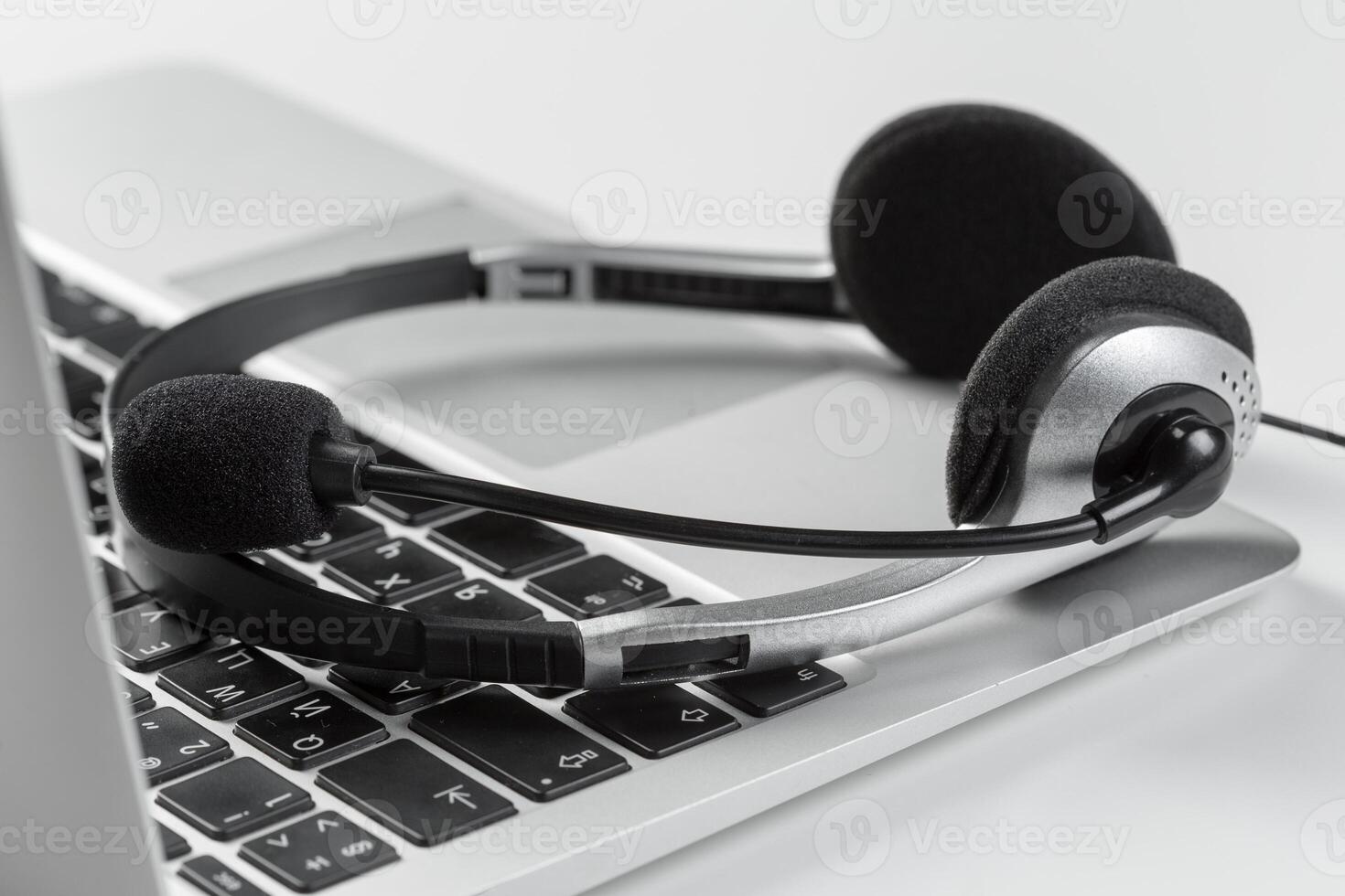 call center support concept. headset on keyboard computer laptop photo