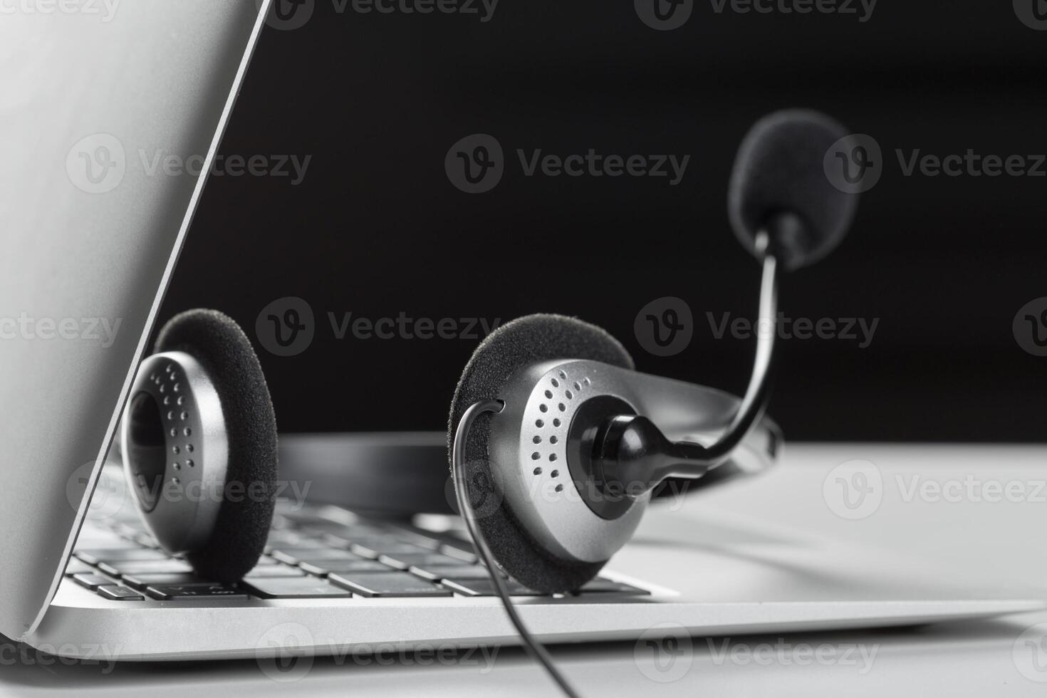 call center support concept. headset on keyboard computer laptop photo