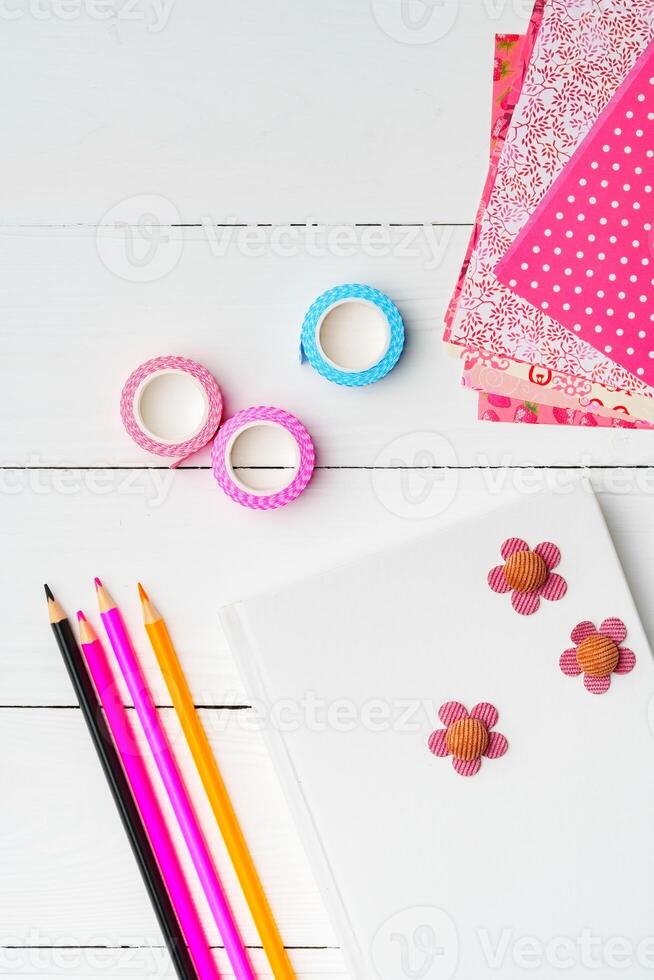 Crafting a colorful workspace with decorations, stationery, and artistic tools on a clean wooden surface photo