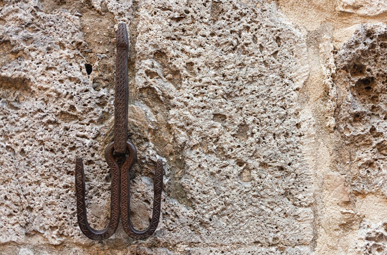 Wrought iron hook of medieval origin in the center of San Gimignano, a small medieval village of Tuscany in the province of Siena. photo