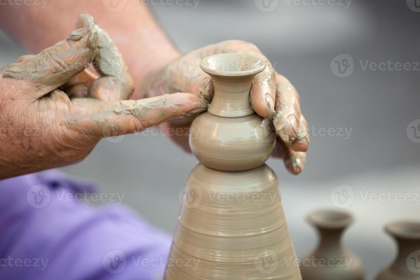 Hands making pottery on a wheel photo