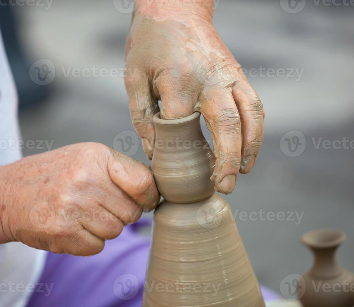 Hands making pottery on a wheel photo