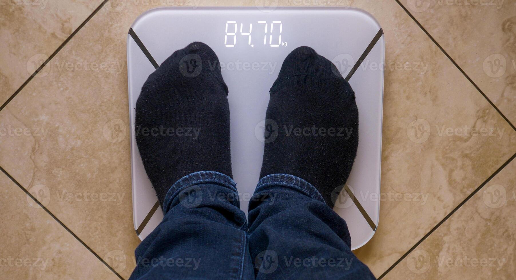 Man weighs himself on a digital scale. Top view. photo