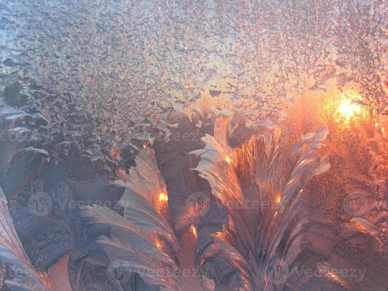 Ice pattern and sunlight on winter glass photo