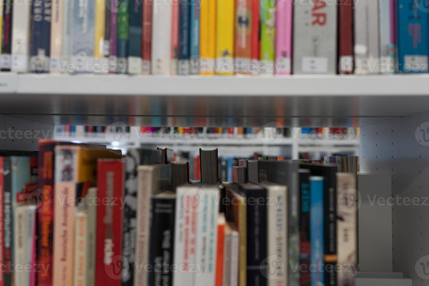 Bookshelf close-up. Lots of books. There are many books on the shelves in the library. The view through the books. photo