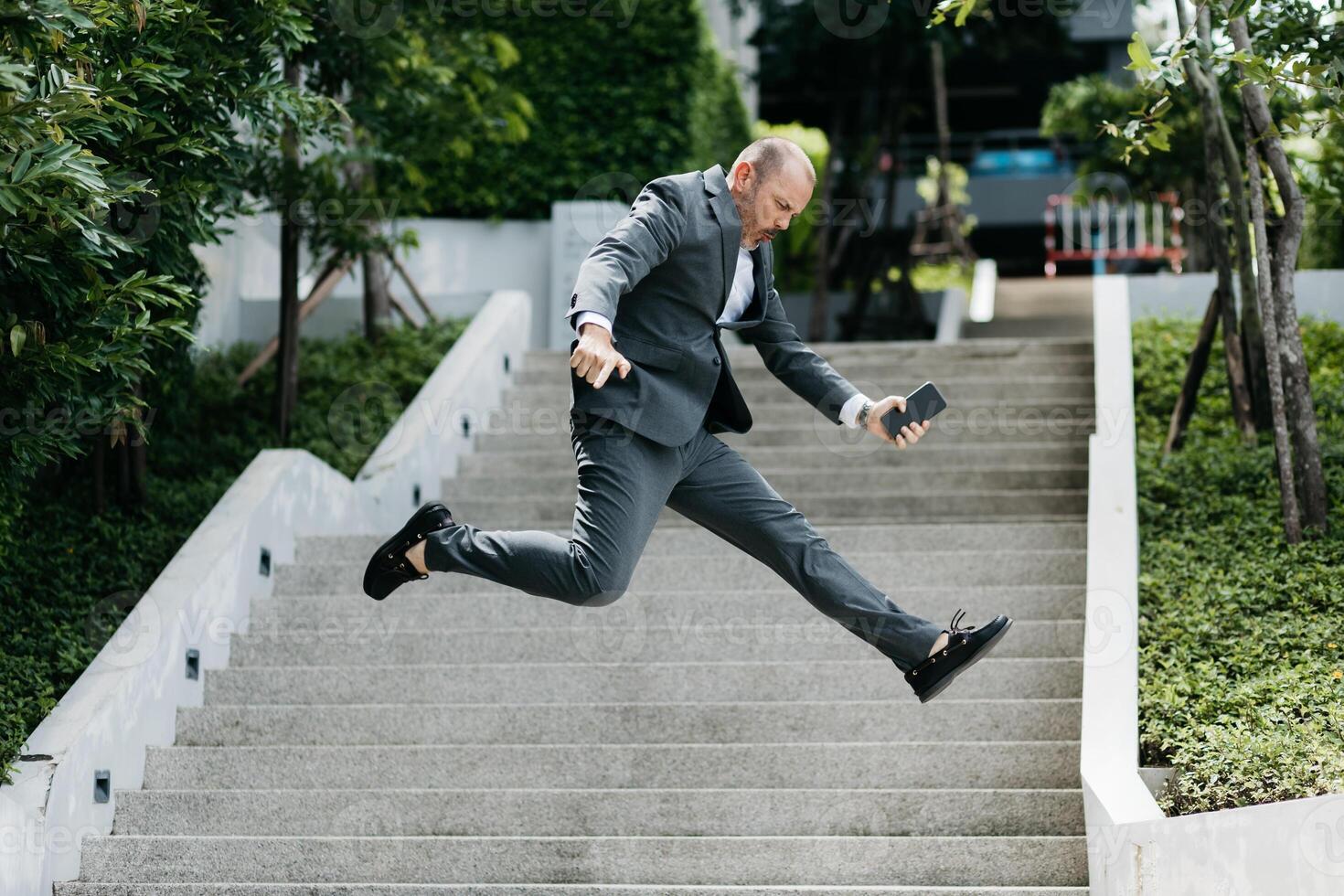 Businessman jumping in the street. Receiving joyful news about a deal completion. Business Ambitions concept. Goal business success strategy. Creative growth development. photo