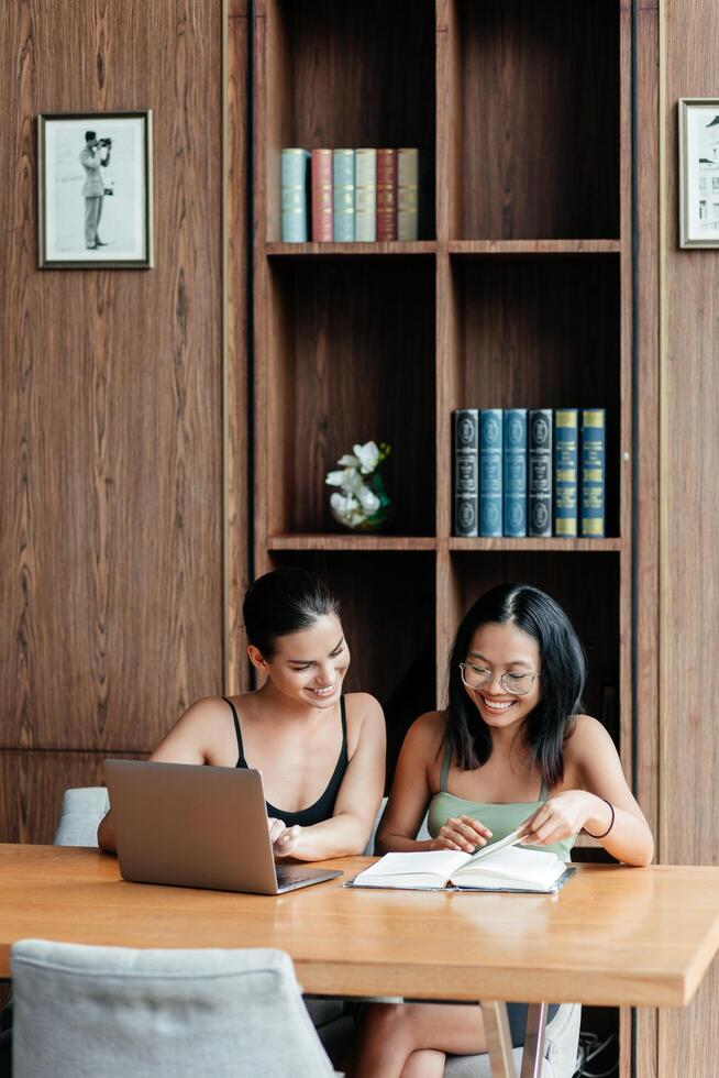 Two multiracial students in a modern office or library discuss ideas for completing an assignment, sharing thoughts and inspiration. The pleasant environment enhances their productive collaboration photo