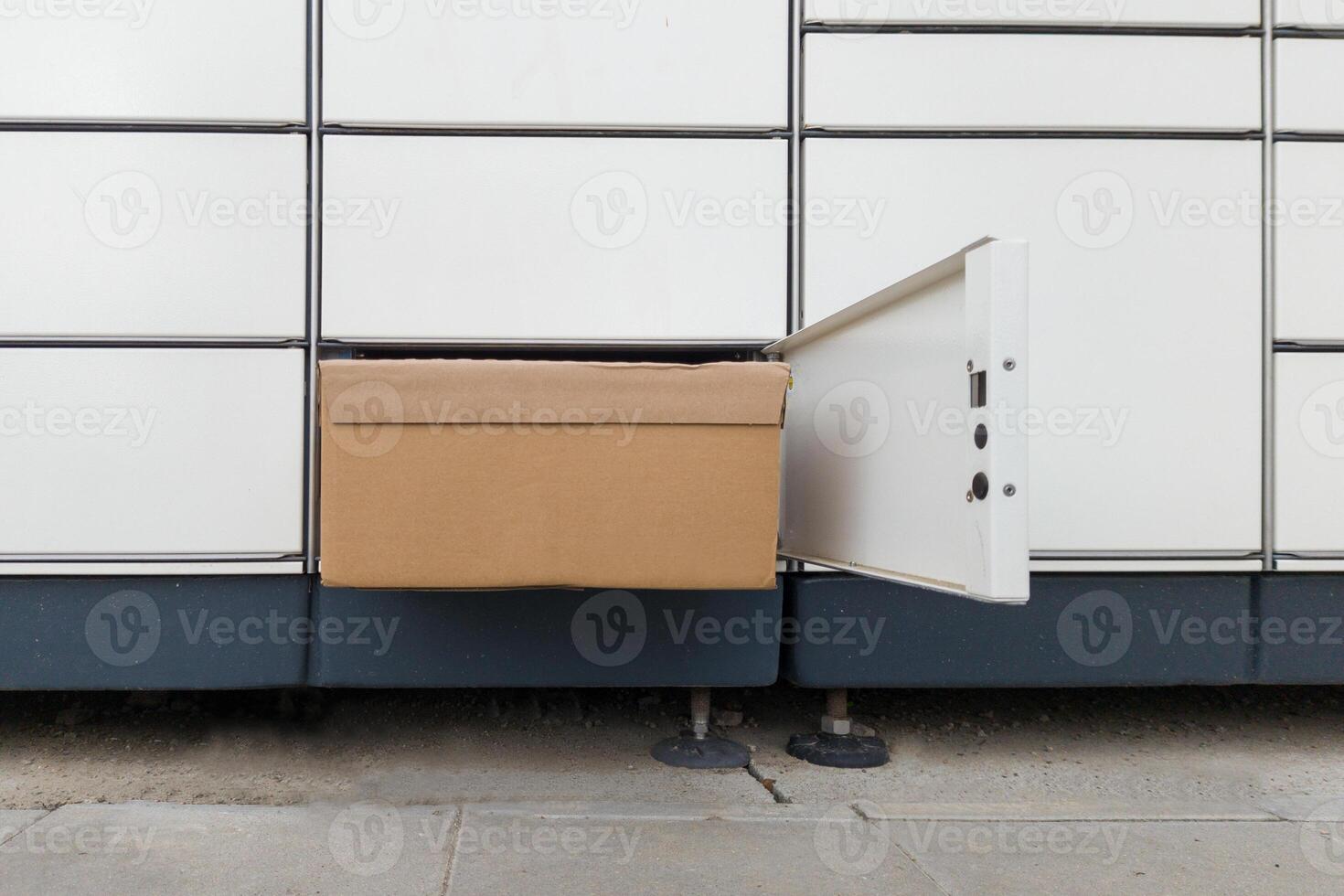 Cardboard Package in Open Parcel Locker Compartment photo