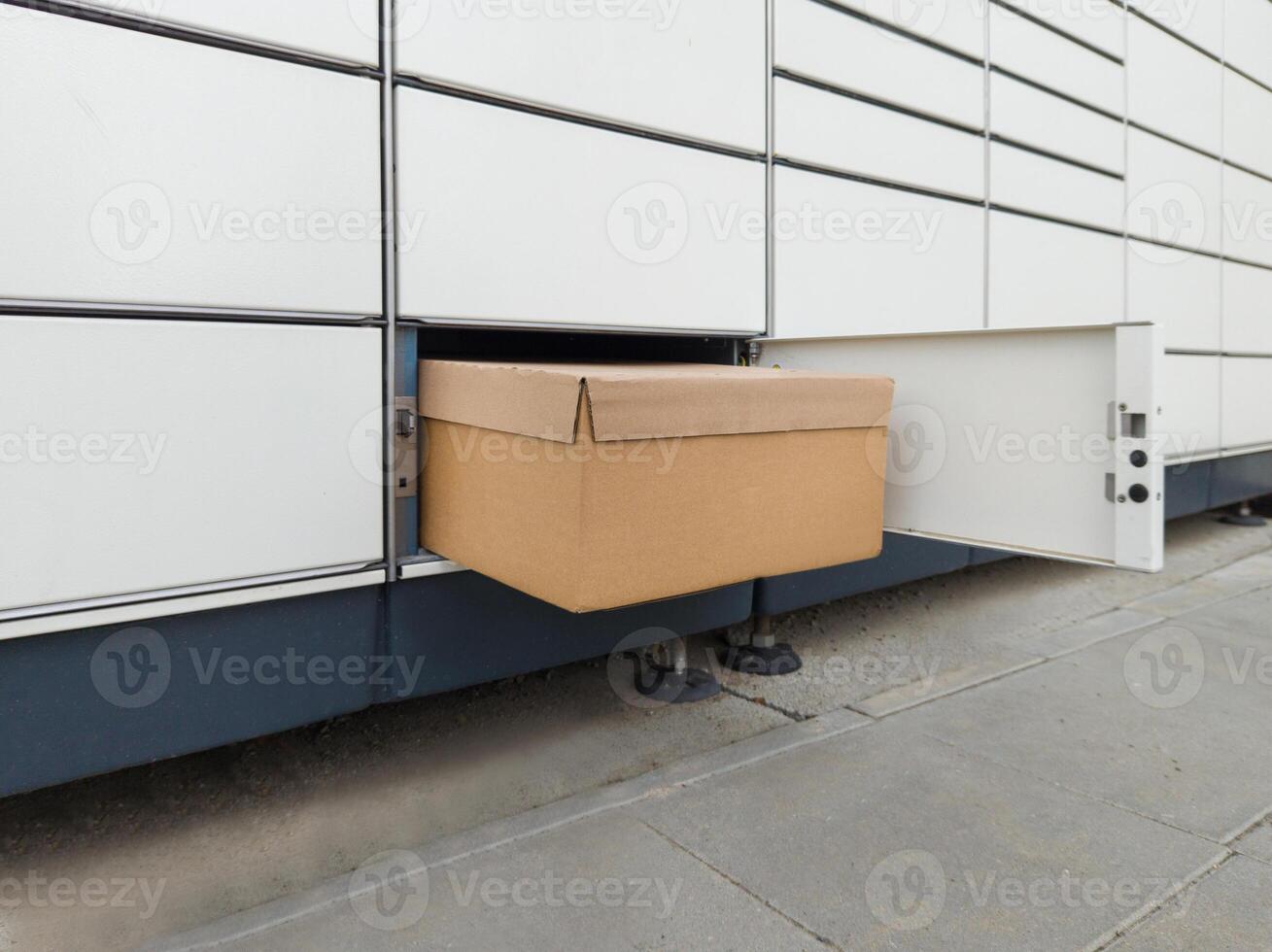 Cardboard Box in Open Parcel Locker Compartment photo