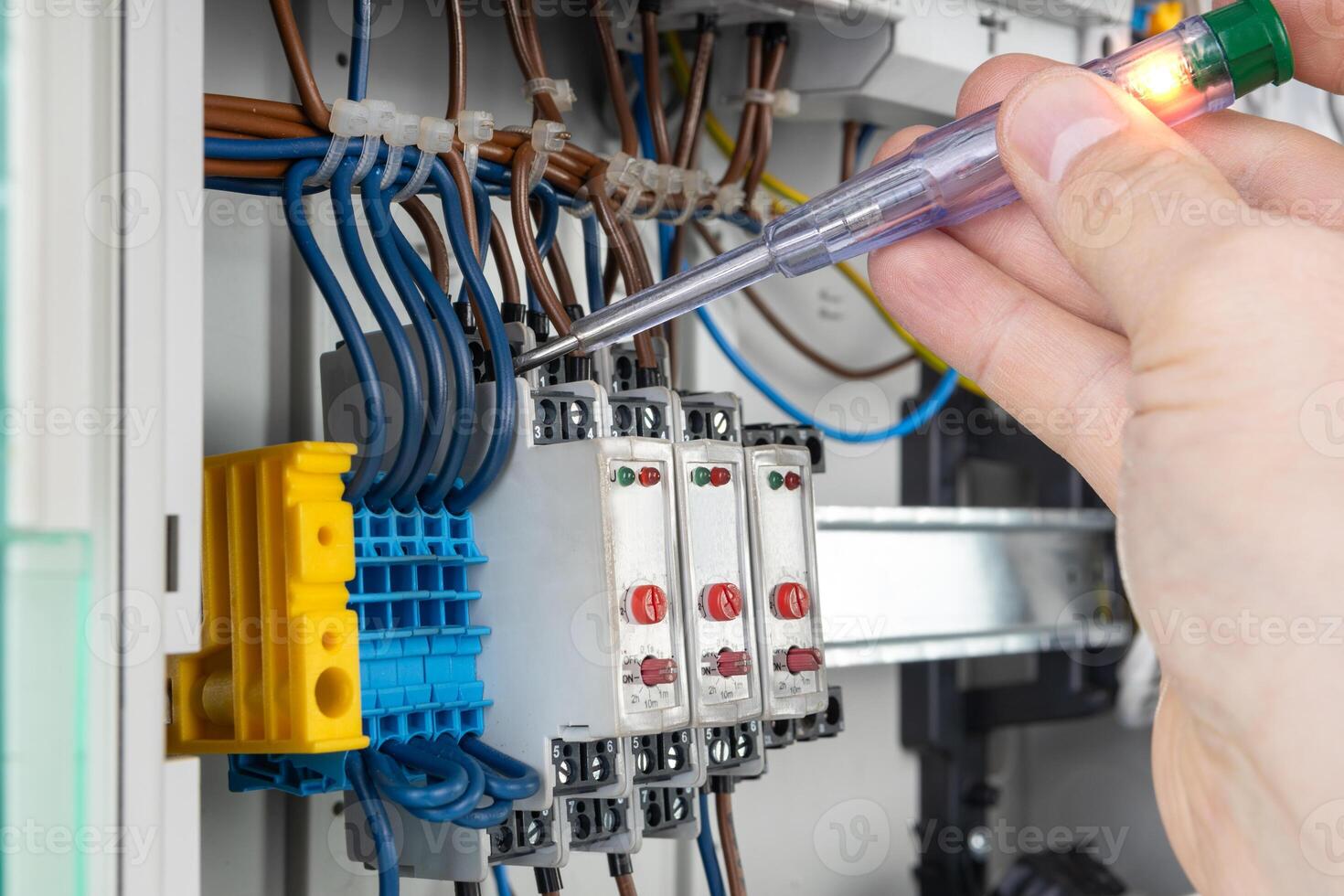 Hand Using Voltage Tester on Electrical Connections photo