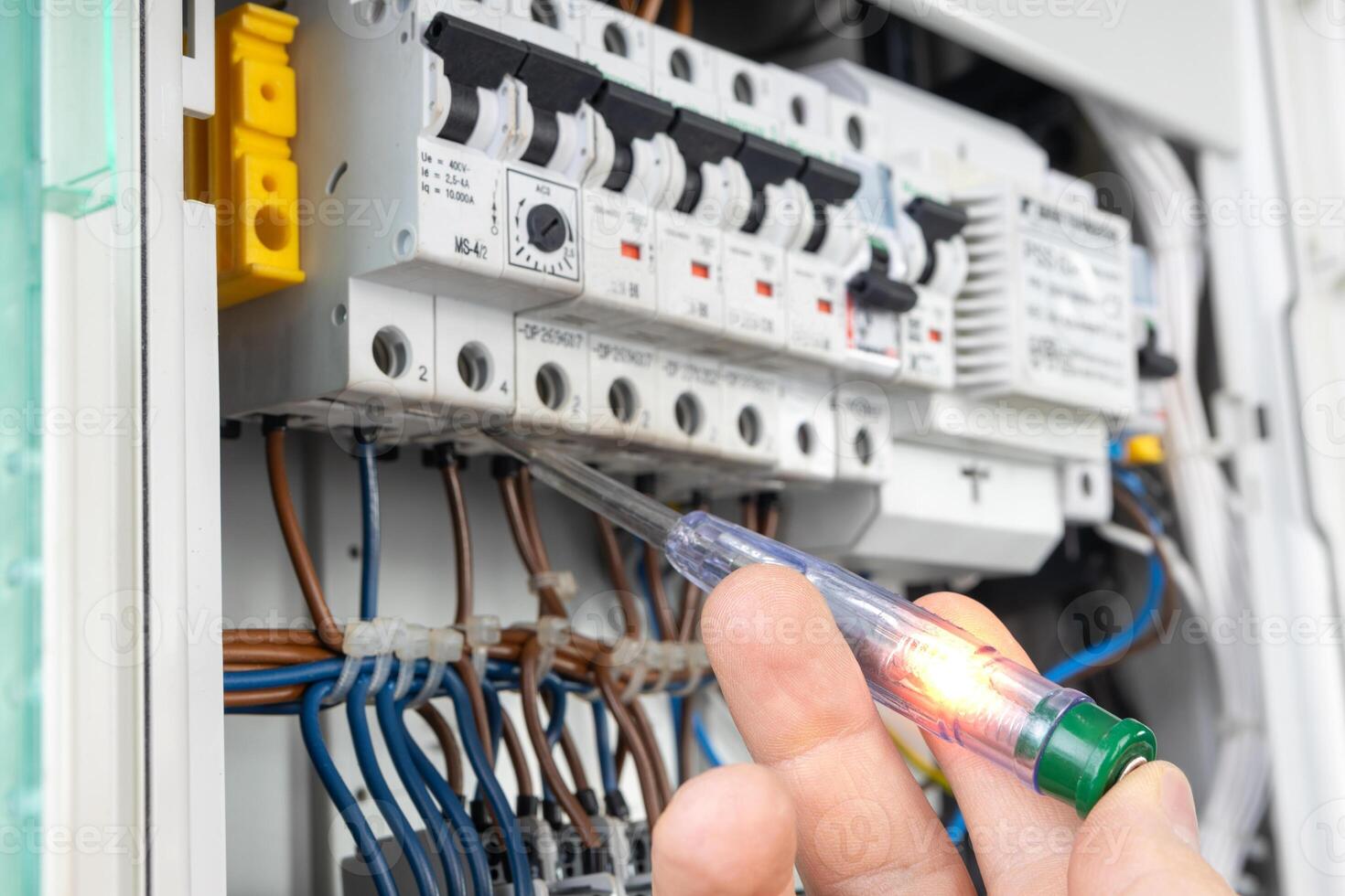 Hand Testing Electrical Circuit with Voltage Tester photo