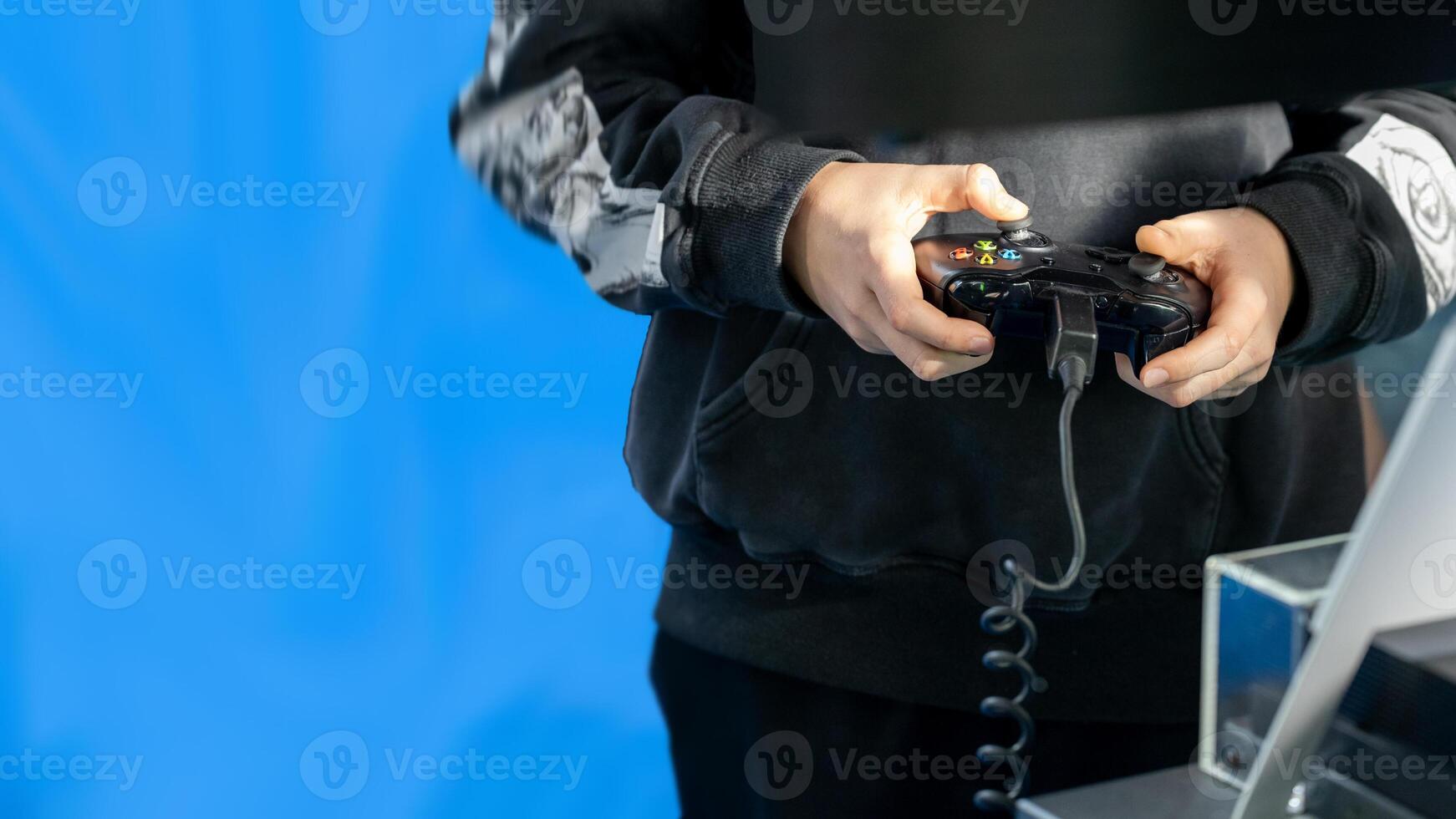 Person Playing Game with Controller on Blue Background photo
