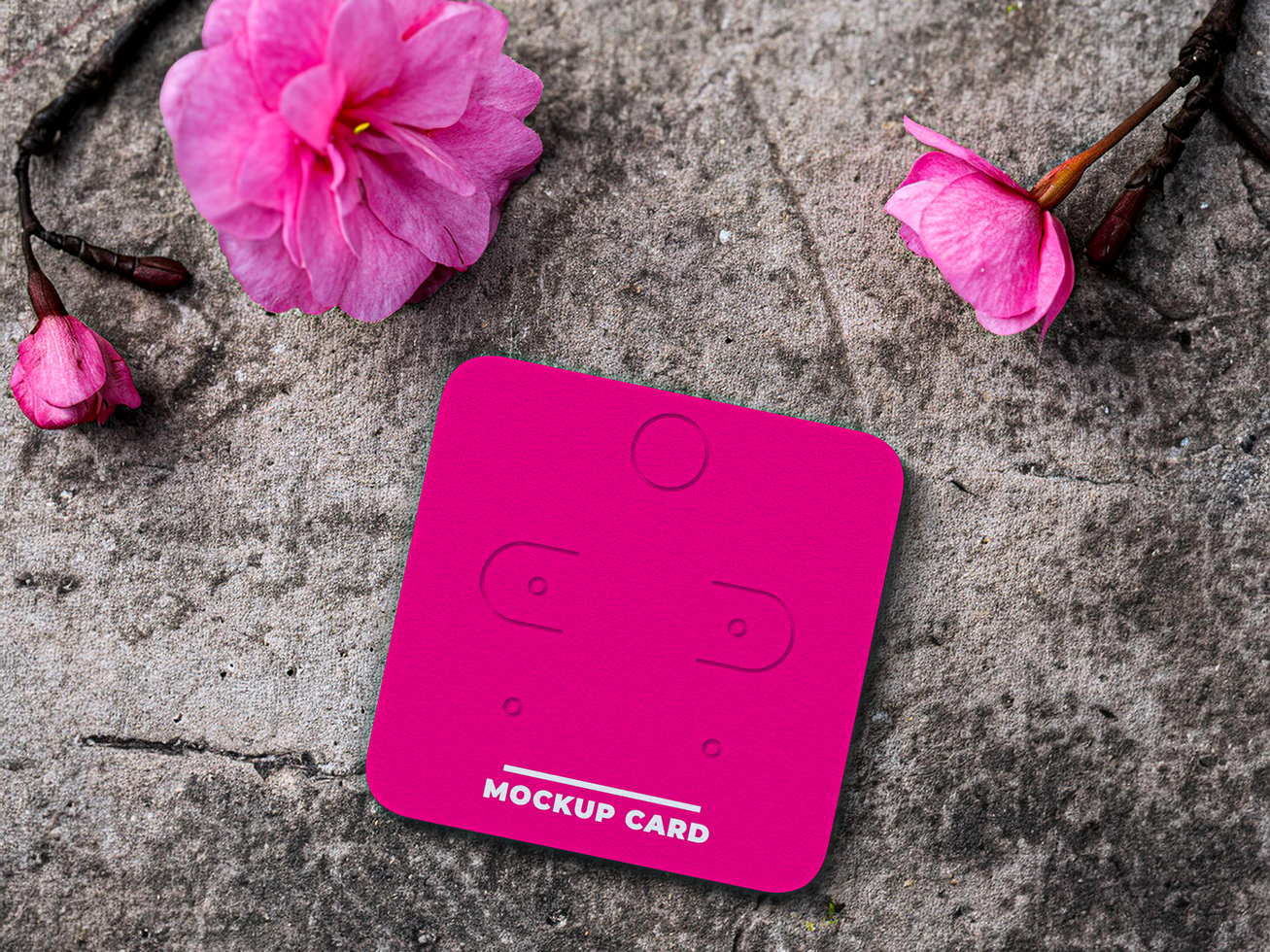 Mockup of earring card on the ground with flowers psd