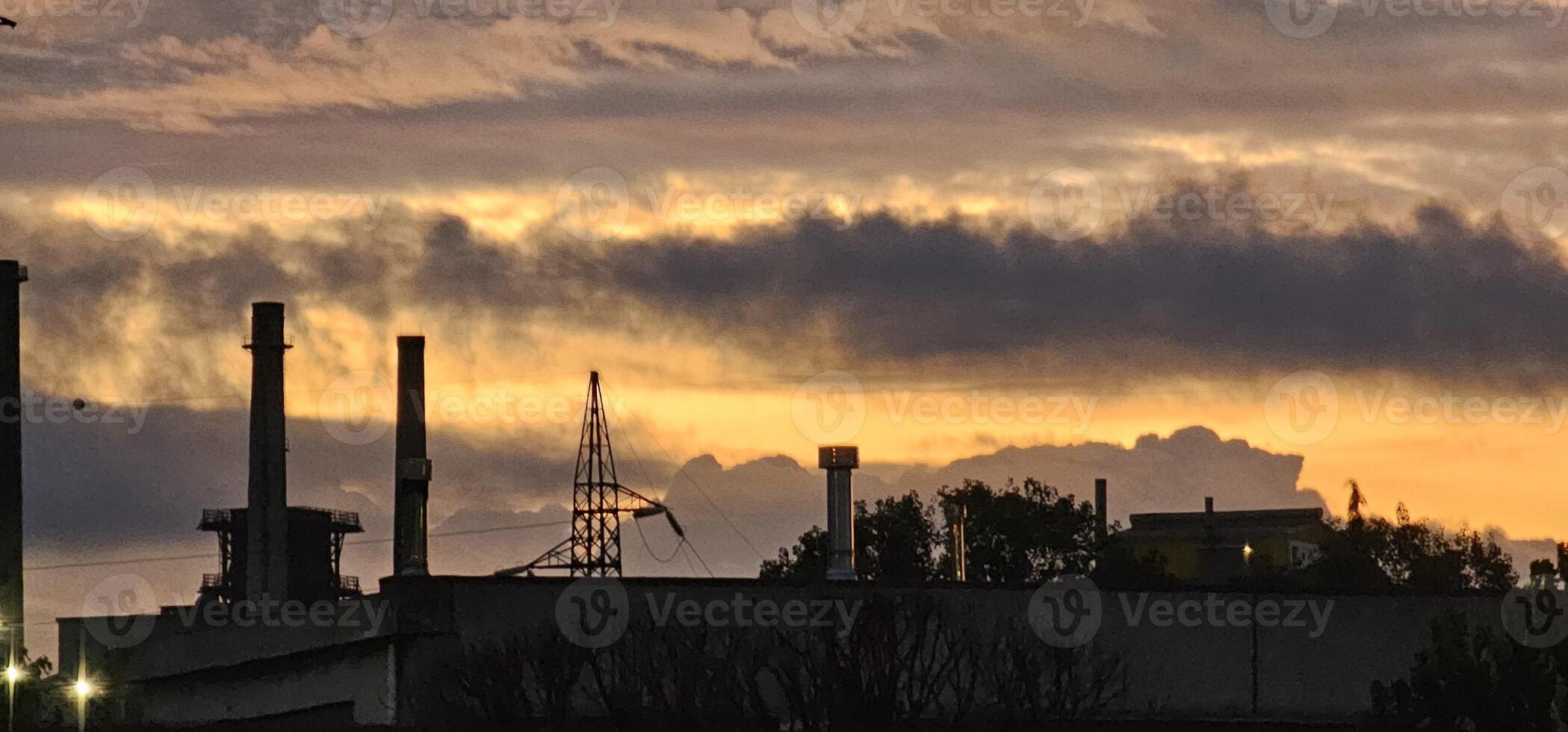 fiery sunset with smog fumes from chimneys at a metalworking industry in Italy photo