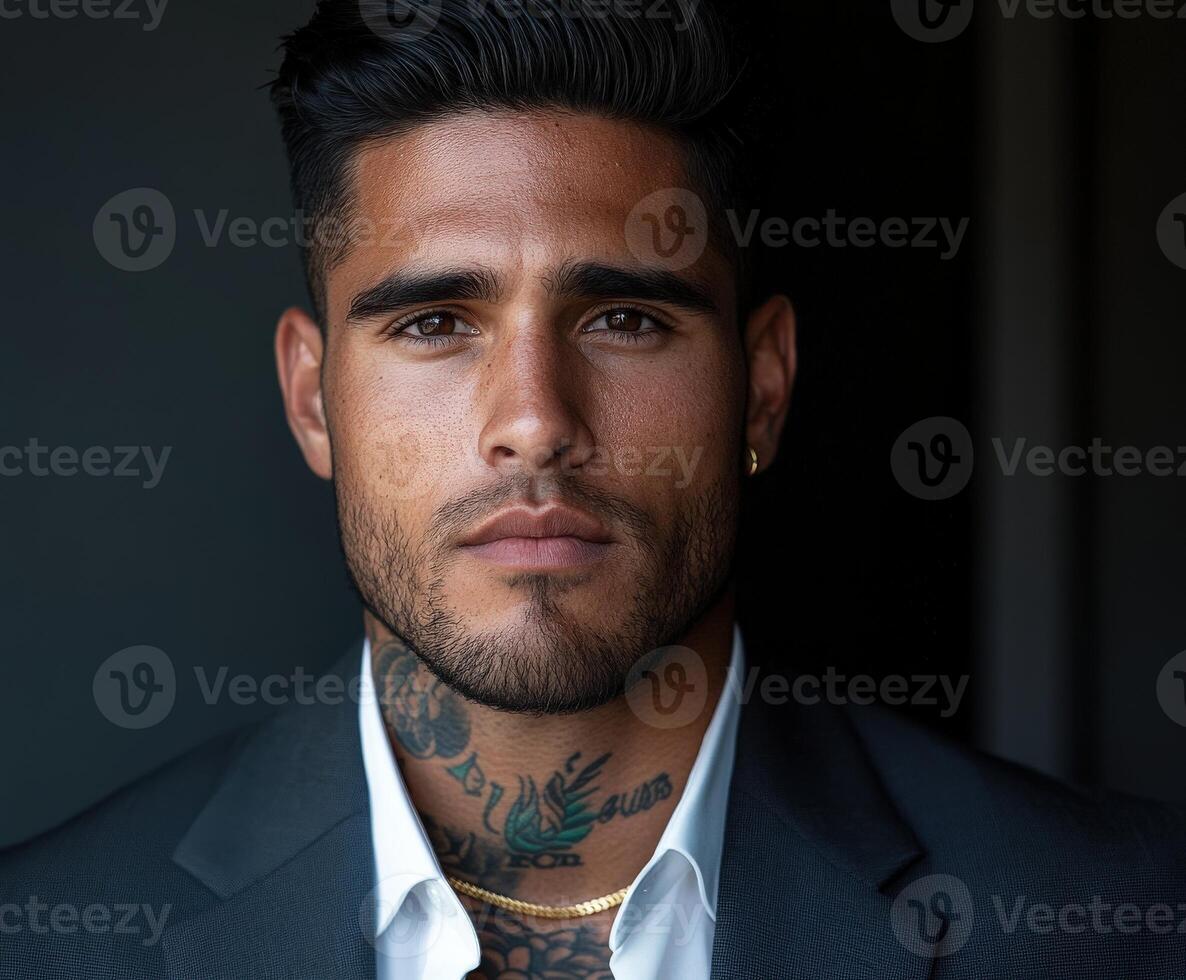 Portrait of a man in a dark suit with tattoos, captured indoors photo