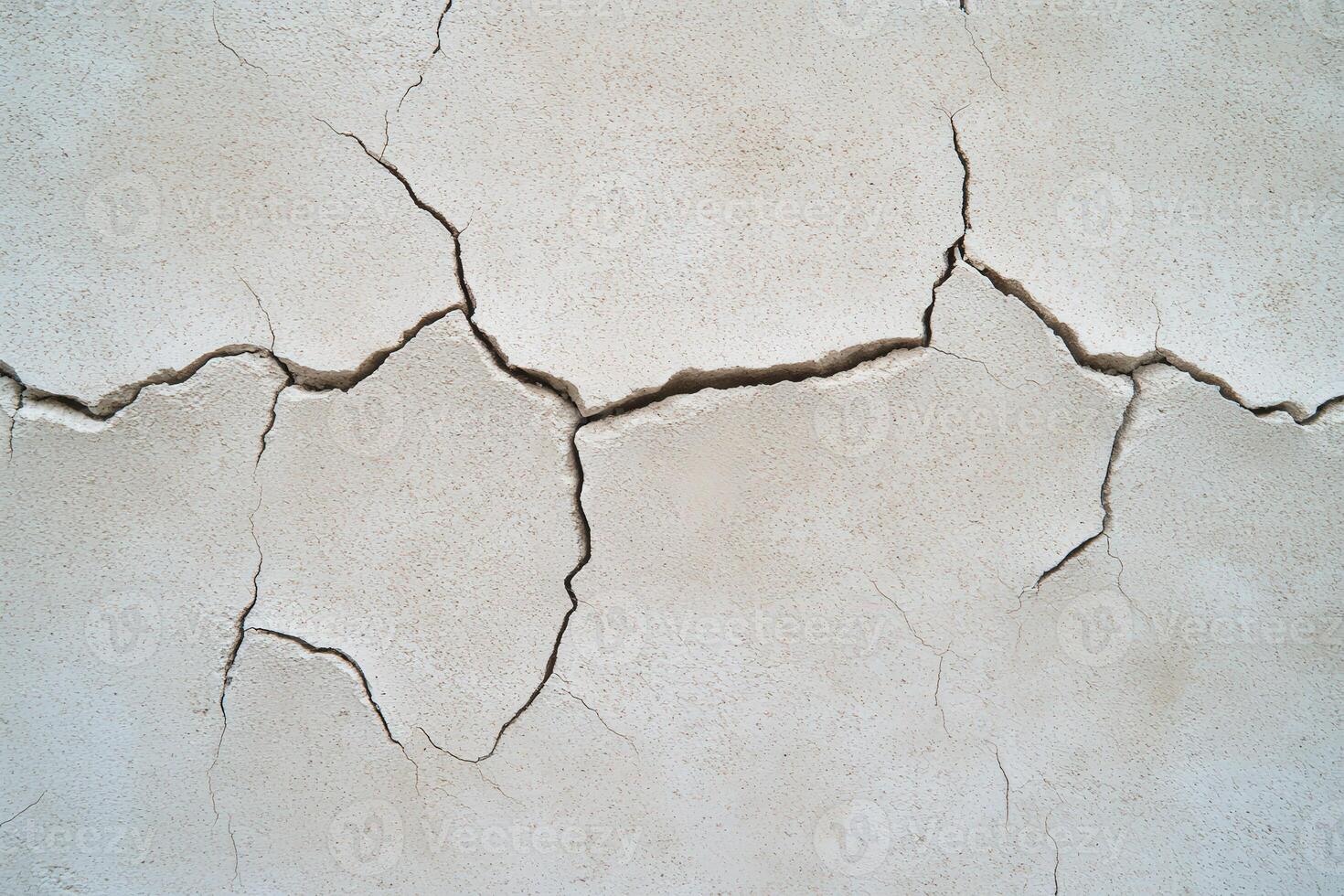 Cracked surface of dry wall showing signs of deterioration and aging photo