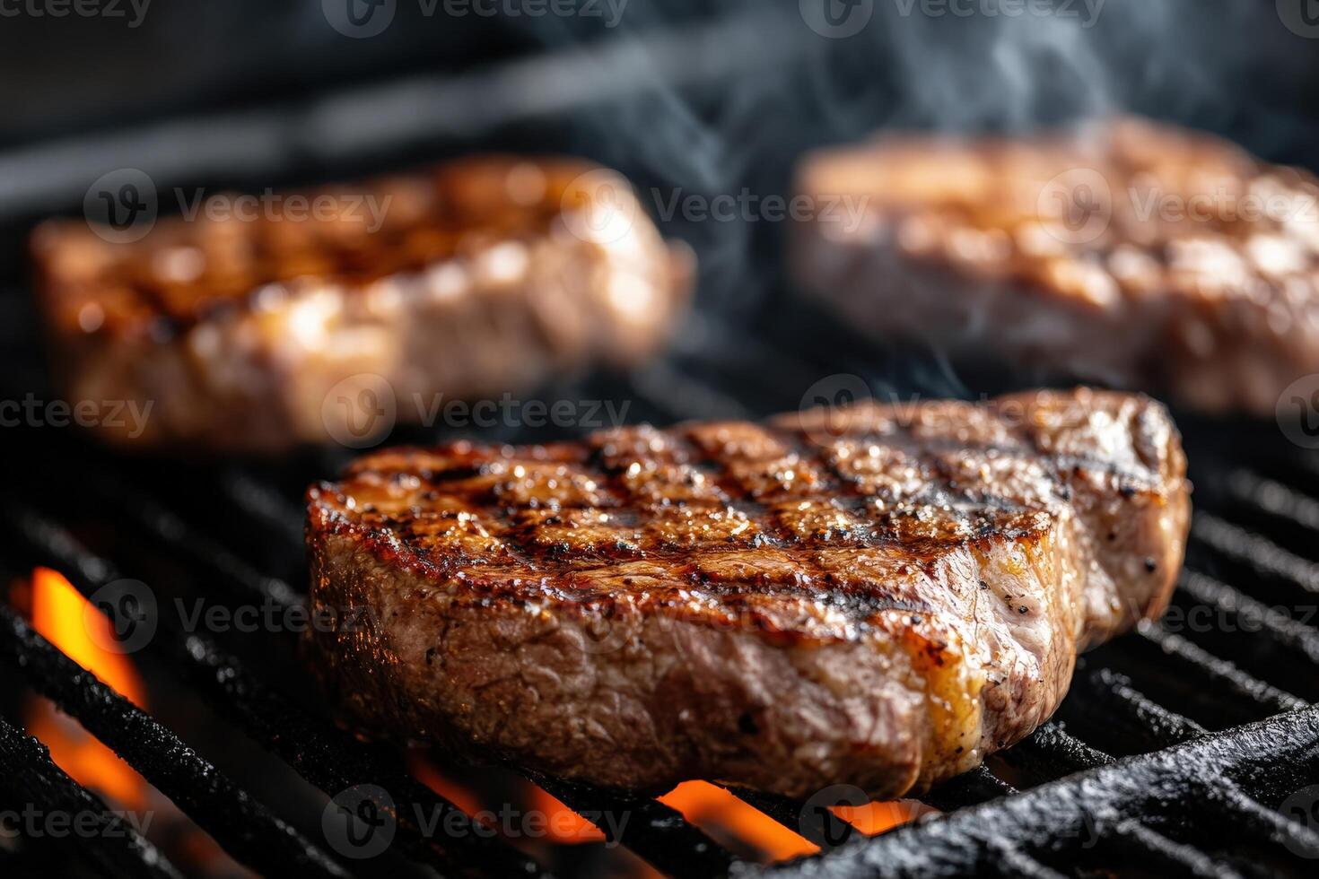 Sizzling beef steaks grilling over hot coals during a summer barbecue photo
