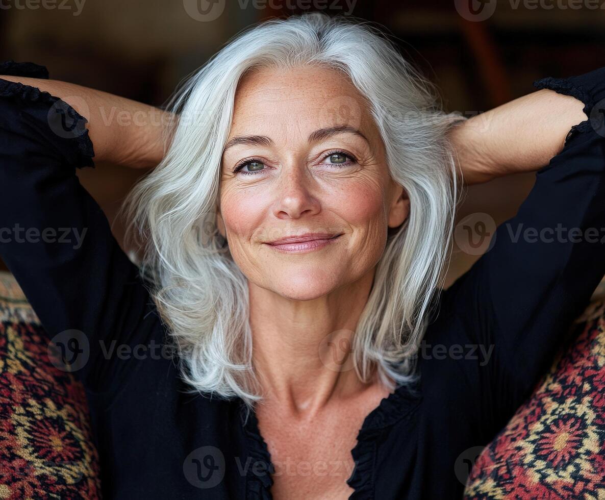 A woman with silver hair relaxes comfortably indoors photo