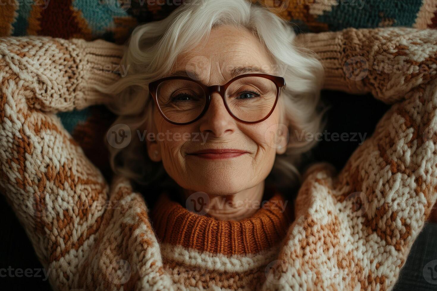 Older woman relaxing at home with a cozy sweater and joyful smile photo