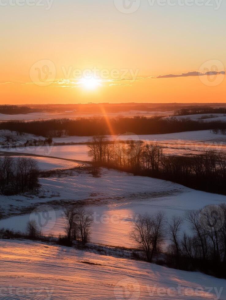 Golden sunset over snowy fields and trees in a peaceful landscape photo