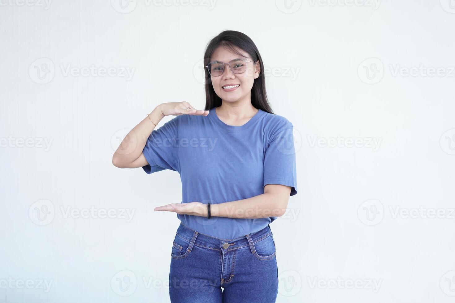 beautiful Asian woman displays a product using both hands, emphasizing it against a white background photo