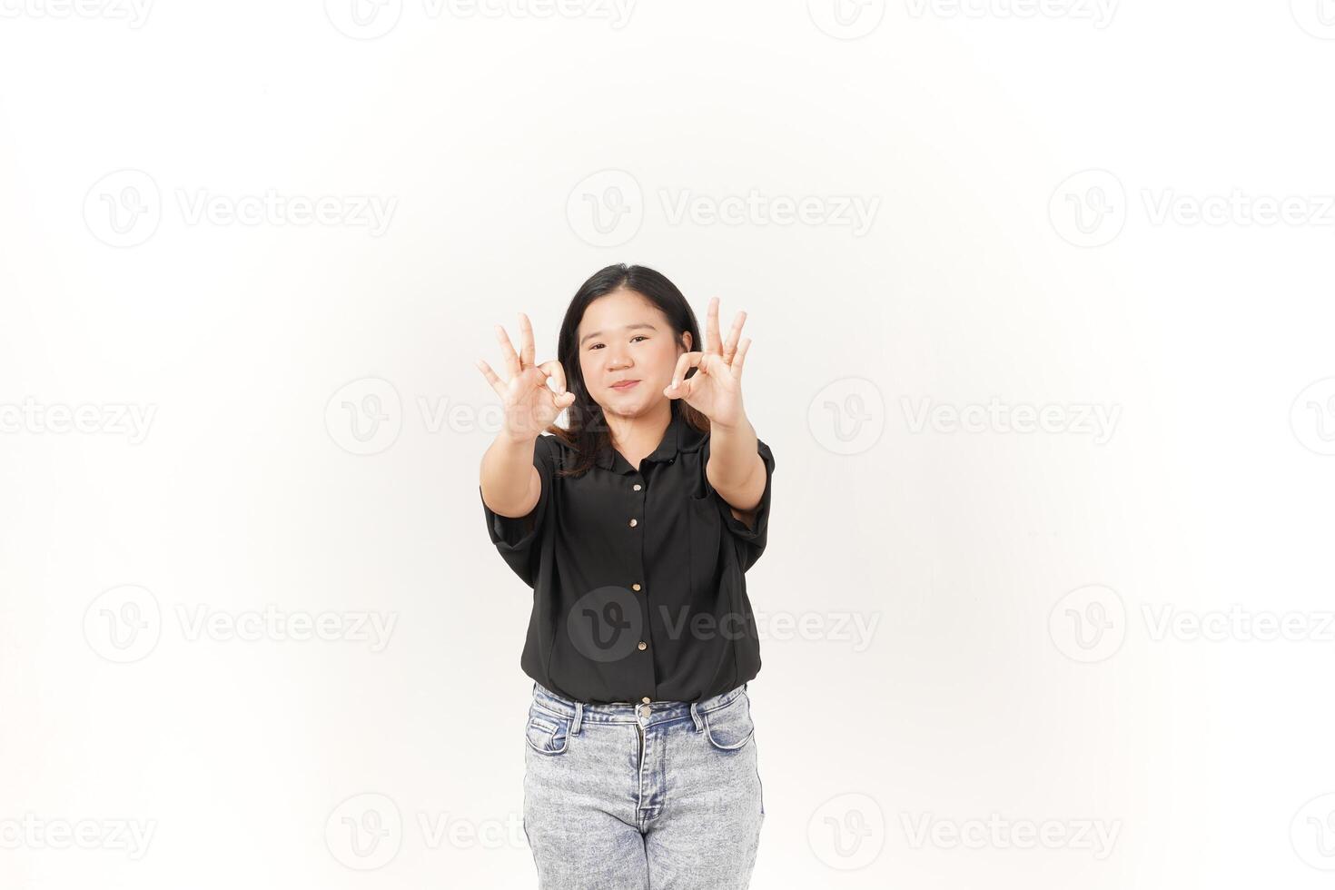 beautiful Asian woman smiles warmly while making an 'OK' hand gesture against a bright white background photo