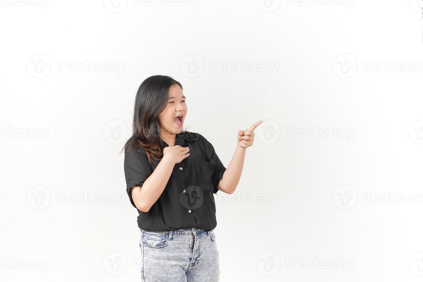 beautiful Asian woman with a shocked expression points emphatically, highlighting surprise against a white background photo