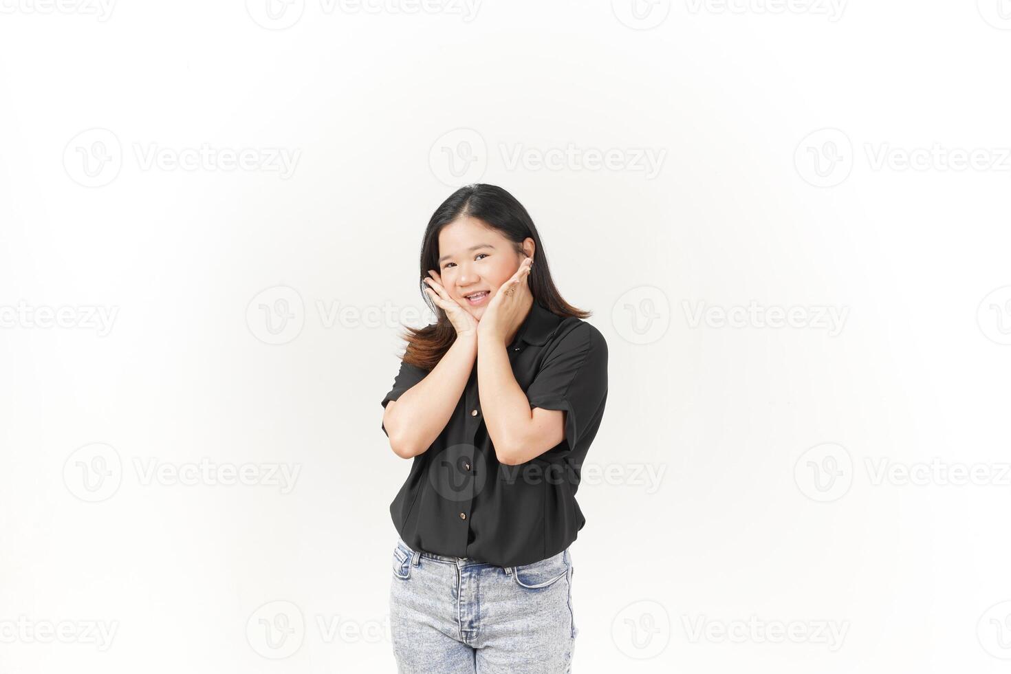 beautiful Asian woman gently holds her cheeks with both palms, showcasing a soft expression against a white background photo