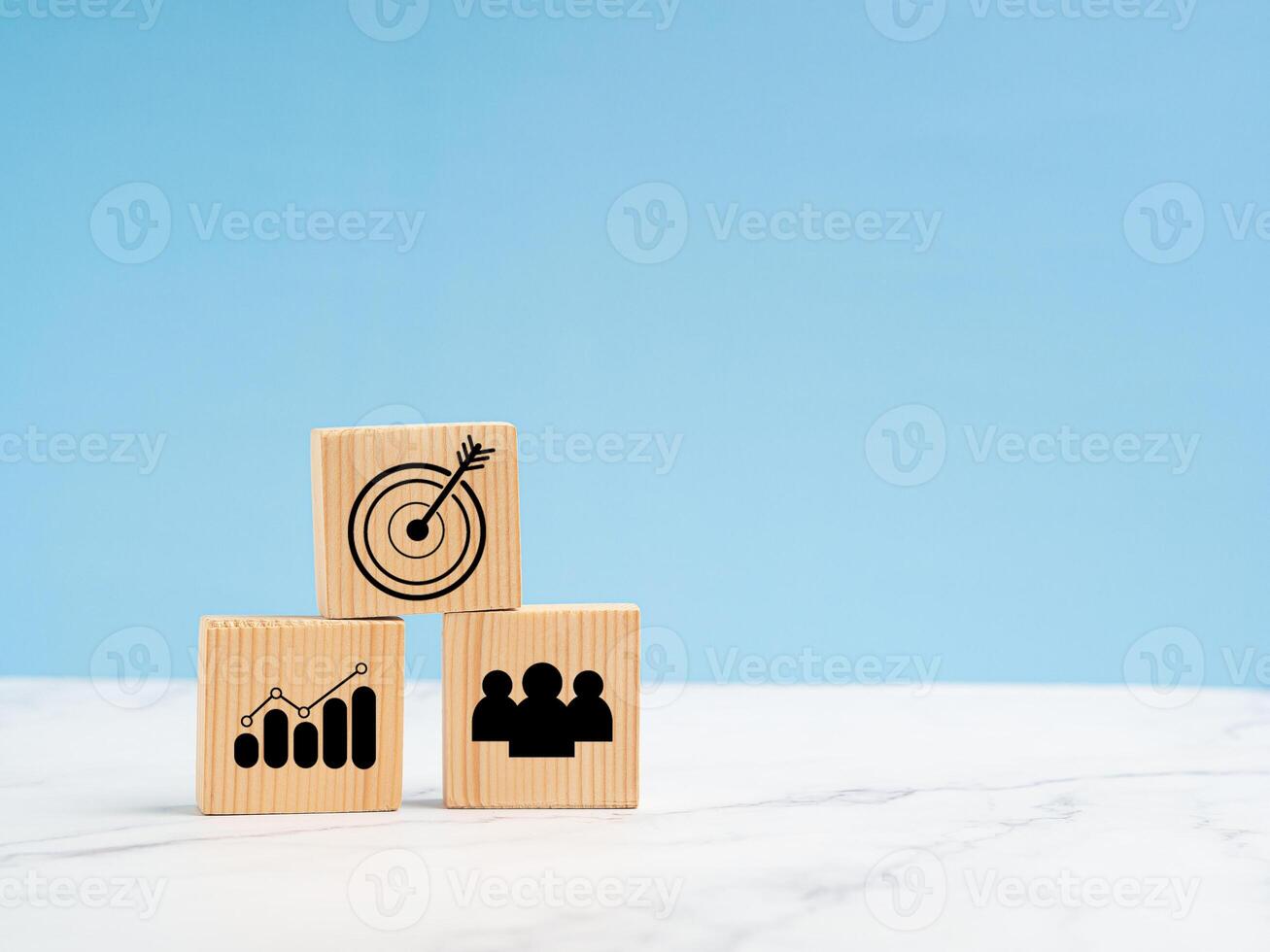 Wooden cubes with icon business strategy over a marble floor against a light blue background photo