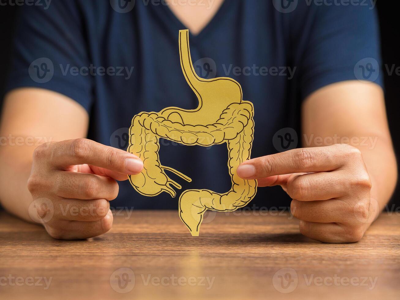Man holding a large intestine shape made from yellow paper photo