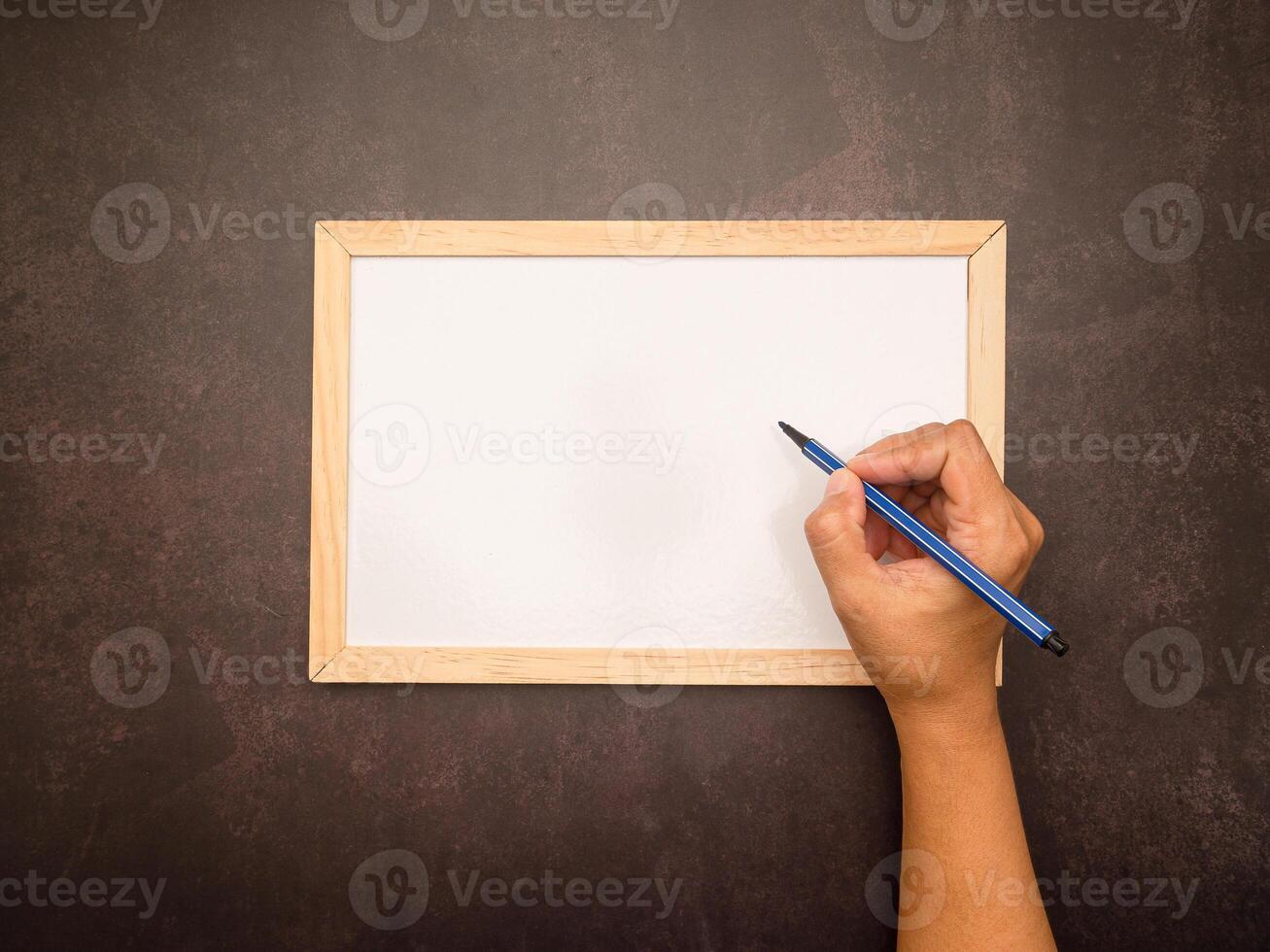 Hand holding chalk about to write something on a mini whiteboard photo