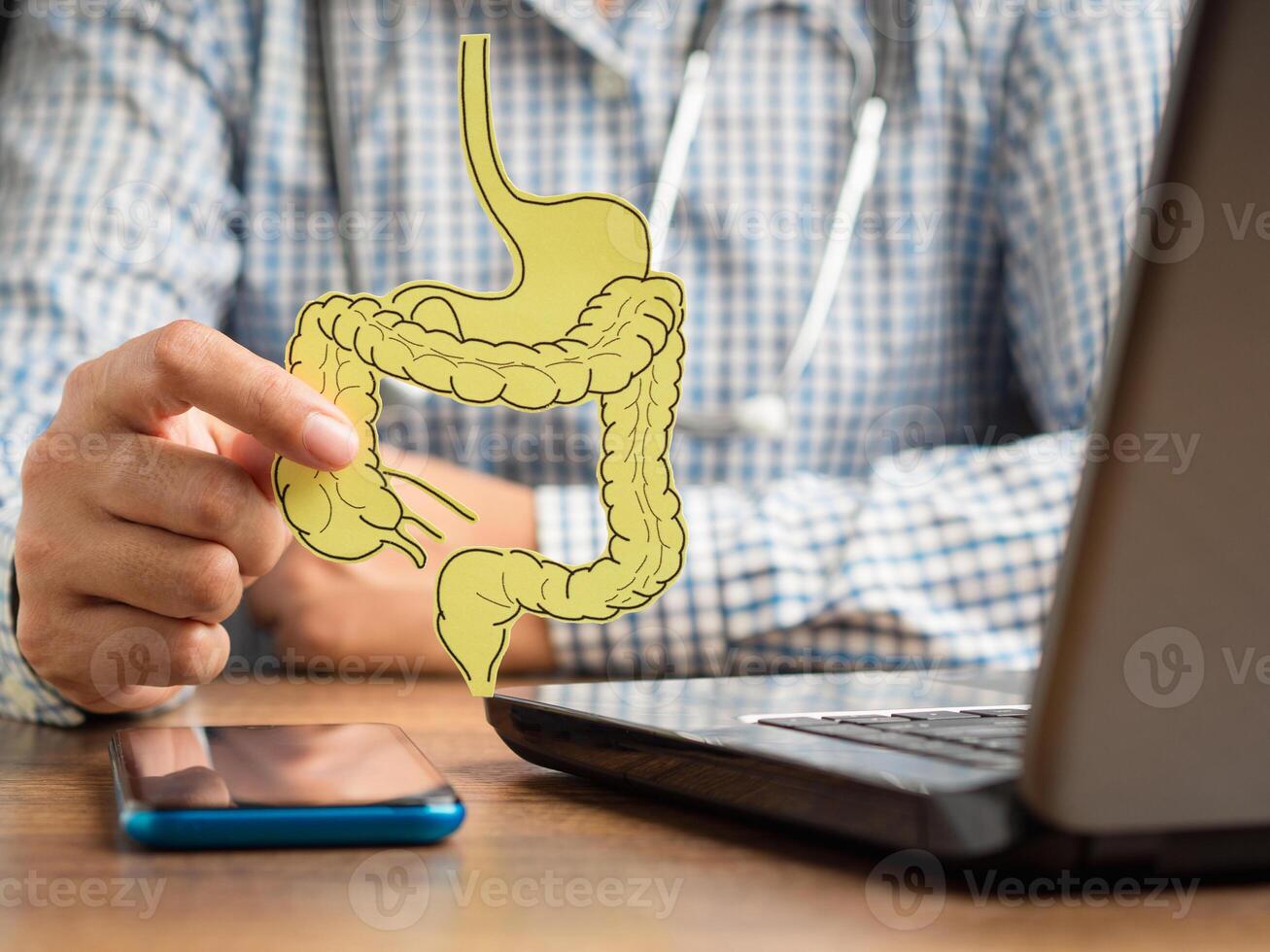 Doctor holding a large intestine shape made from yellow paper photo